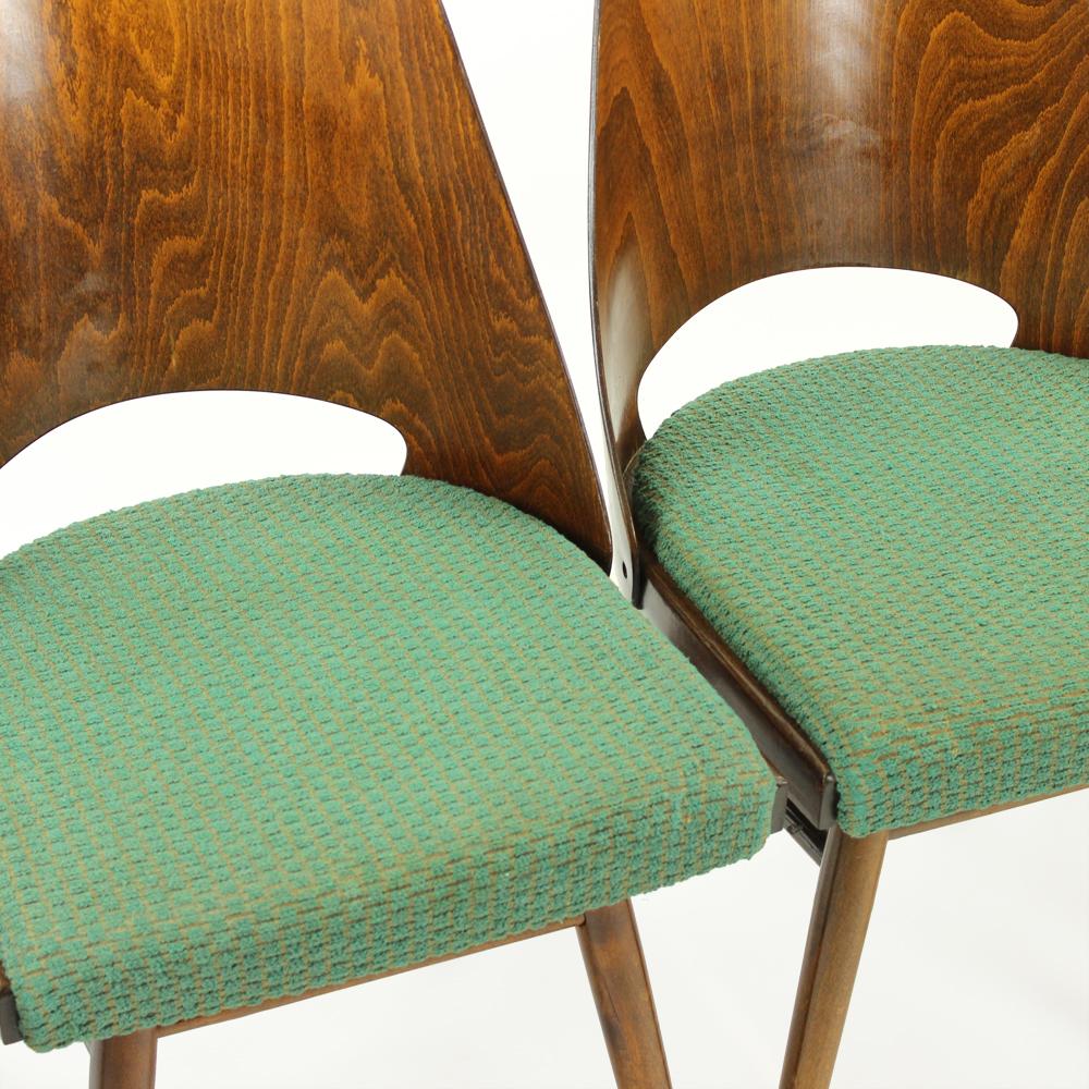 Beautiful set of four chairs produced in Czechoslovakia by TON company in 1960s. The chairs have a bended plywood backrest, original label. Walnut wood finish. Seat is in original green fabric. Minor wear shows on two of the seats, but they are all