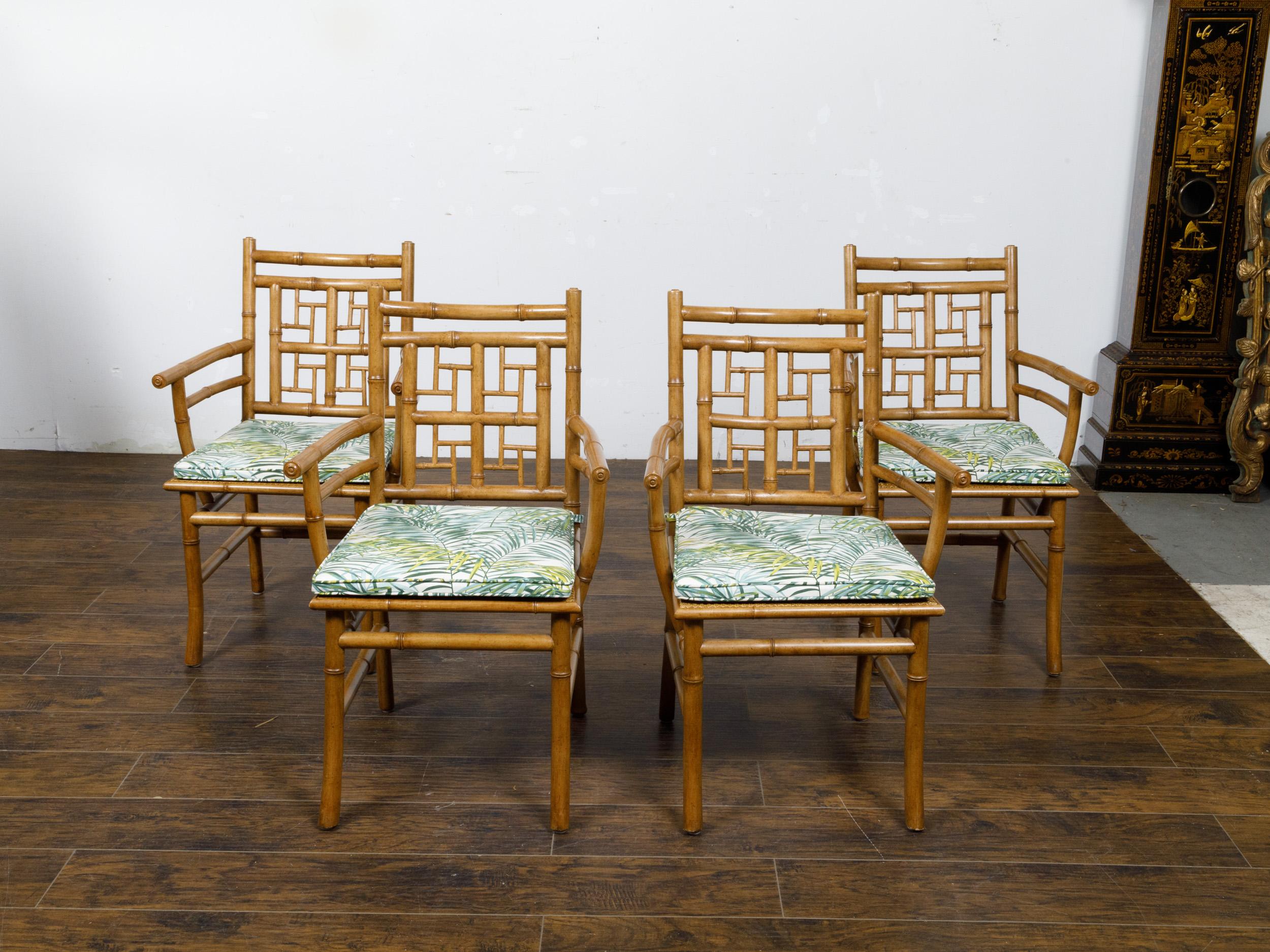A set of four English Midcentury faux bamboo armchairs with thin cushions. This set of four English Midcentury armchairs, crafted in the sought-after faux bamboo style, presents an exquisite example of timeless elegance fused with a touch of exotic