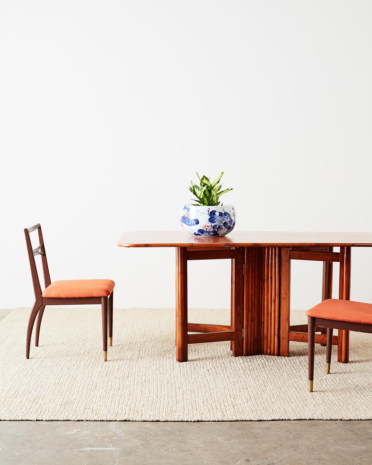 Sleek set of four Mid-Century Modern dining chairs featuring a chocolate colored lacquer finish. The painted frames have a simple elegant style with a narrow, ladder style backsplat and thin upholstered seat in a playful orange textured fabric.