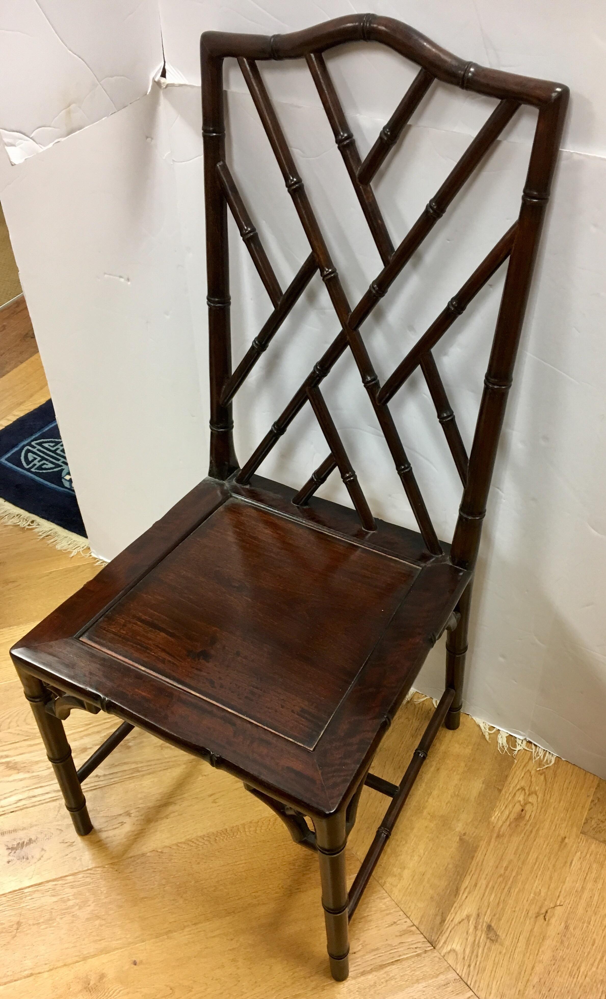Mid-Century Modern era set of pristine Chinese Chippendale dining chairs done in mahogany wood and featuring the coveted faux bamboo look. The seat height measures eighteen inches and all other dimensions are below. Color is dark brown.