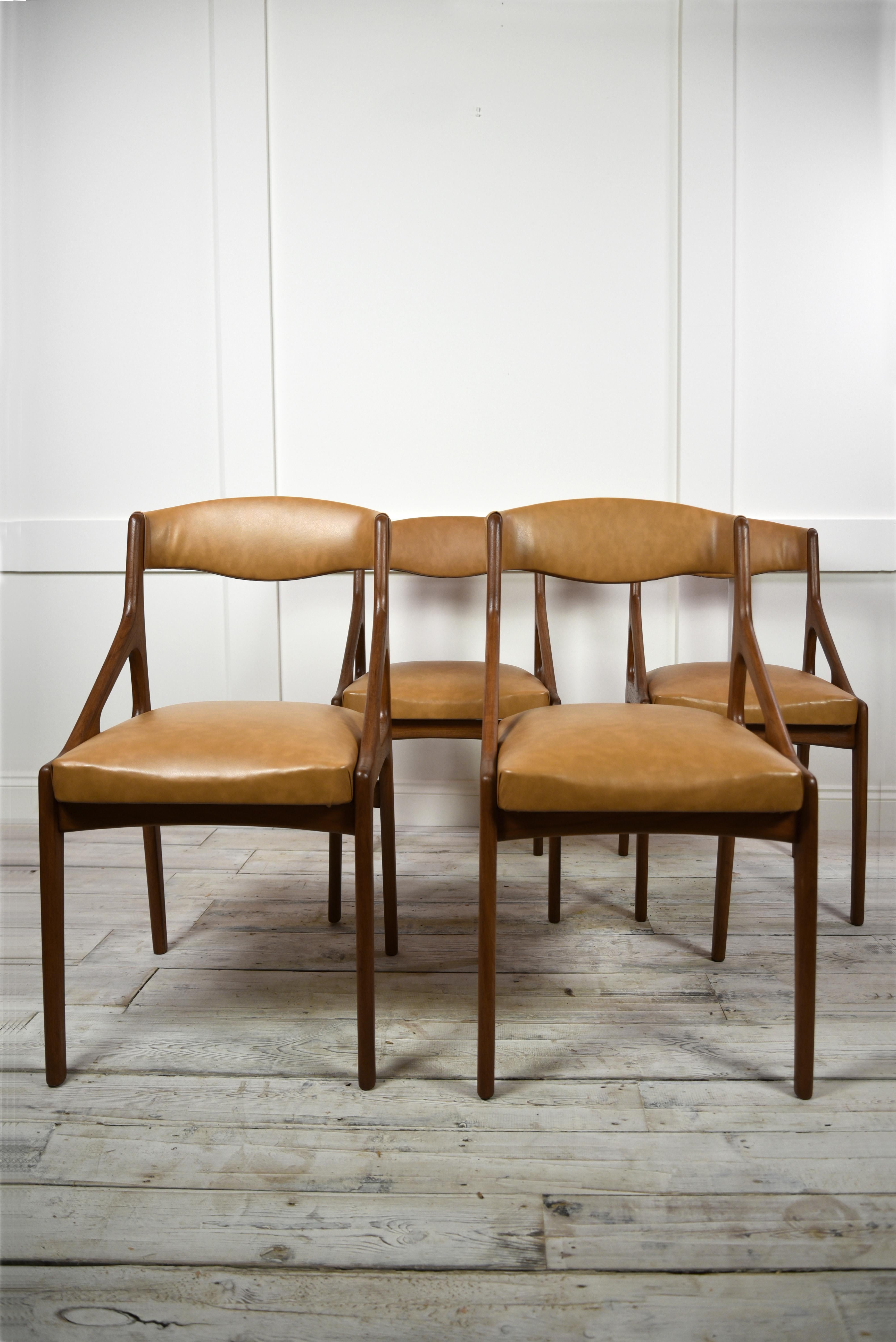 A set of four midcentury modern dining chairs, crafted from high-quality teak wood and luxurious tan Leatherette upholstery. These chairs were made in Italy circa 1960's in the style of renowned designer Kai Kristainsen designs, known for his iconic