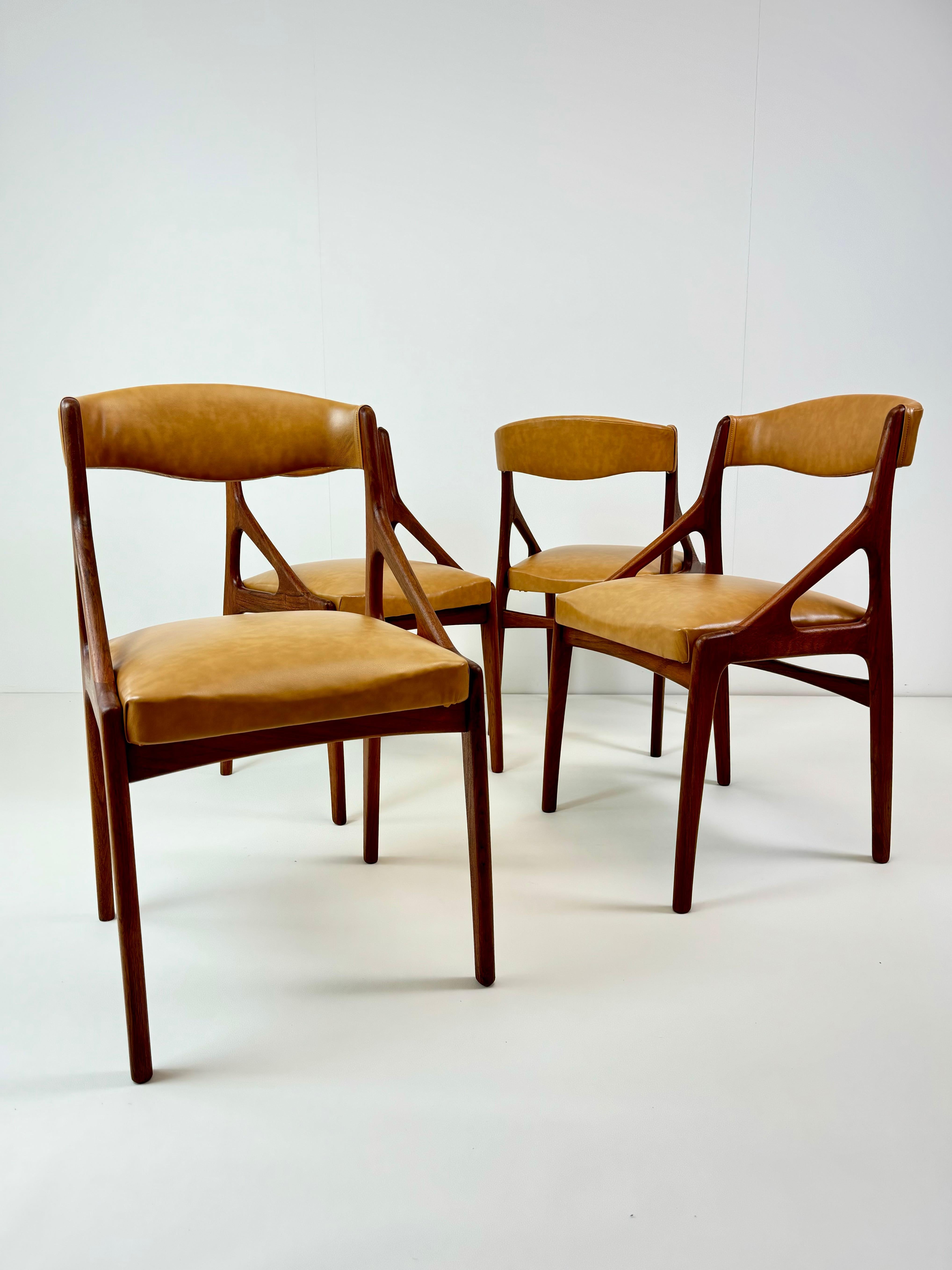 Un ensemble de quatre chaises de salle à manger modernes du milieu du siècle, fabriquées en bois de teck de haute qualité et recouvertes d'un luxueux revêtement en simili-cuir. Ces chaises ont été fabriquées en Italie vers les années 1960 dans le