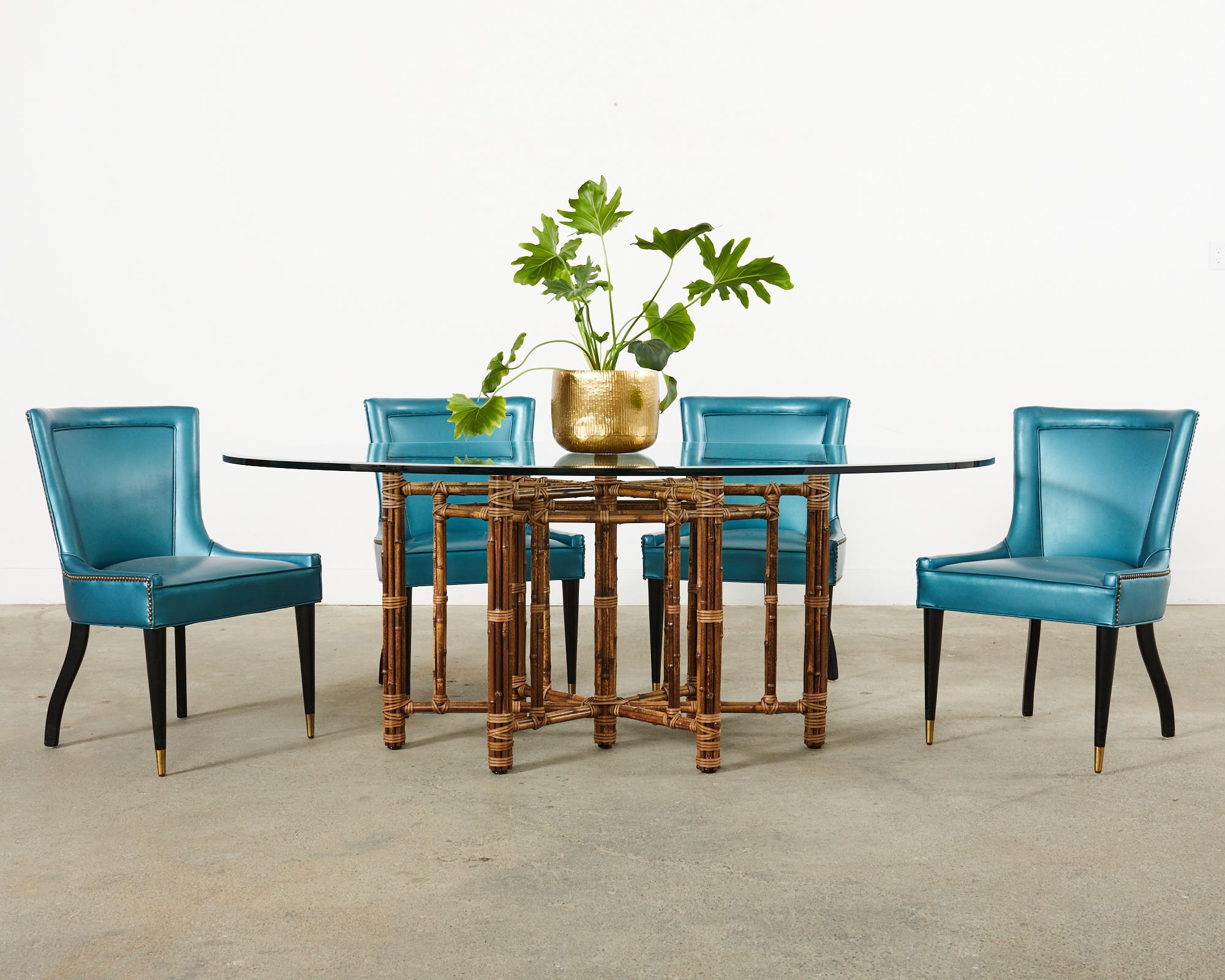 Attractive set of four mid-century modern space age style dining chairs crafted in Italy. The chairs feature a wooden frame upholstered with a modern metallic style teal naugahyde fabric. The seats have patinated brass tack nail heads bordering the