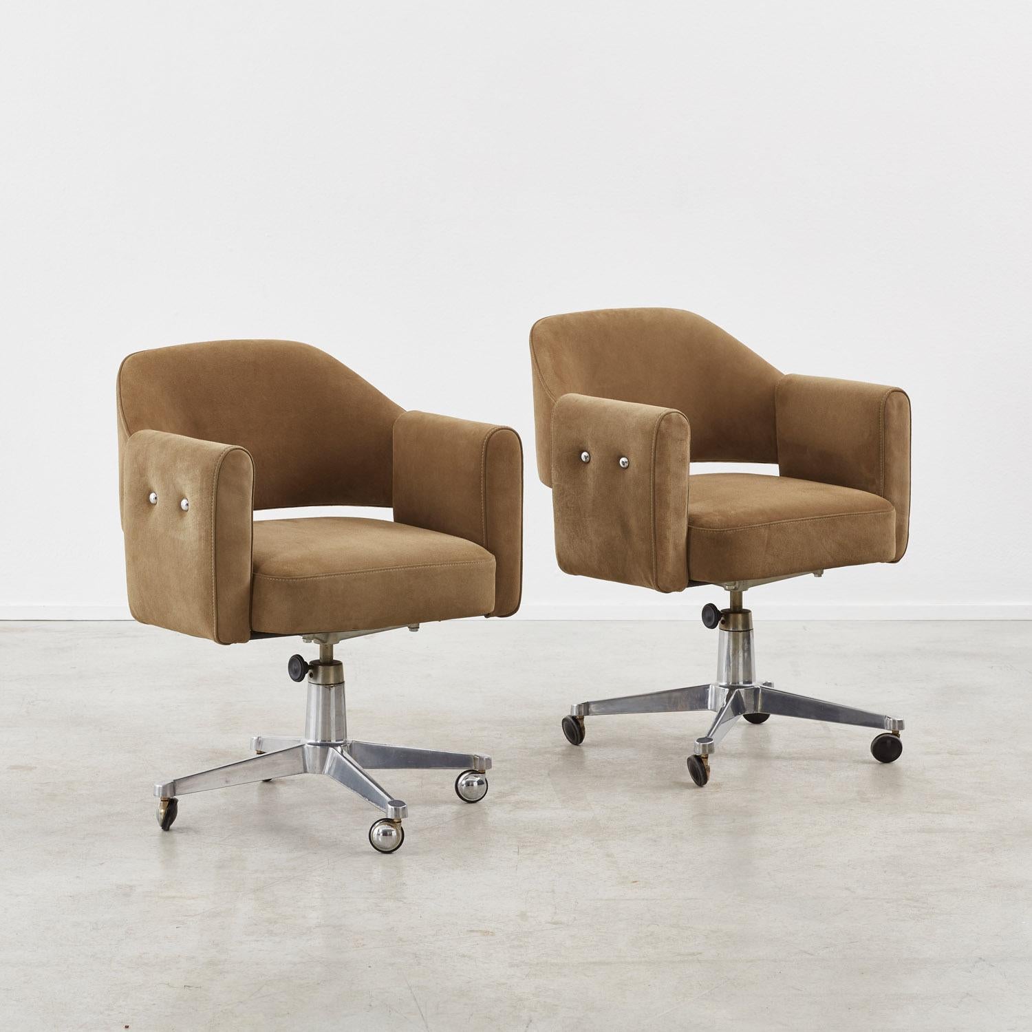Reminiscent of Eero Saarinen’s influential Conference design, these substantial swivel desk chairs wrap the sitter in padded leather. Generous rectangular armrests with an unusual double stud detail connect the curved backrest and seat, while steel