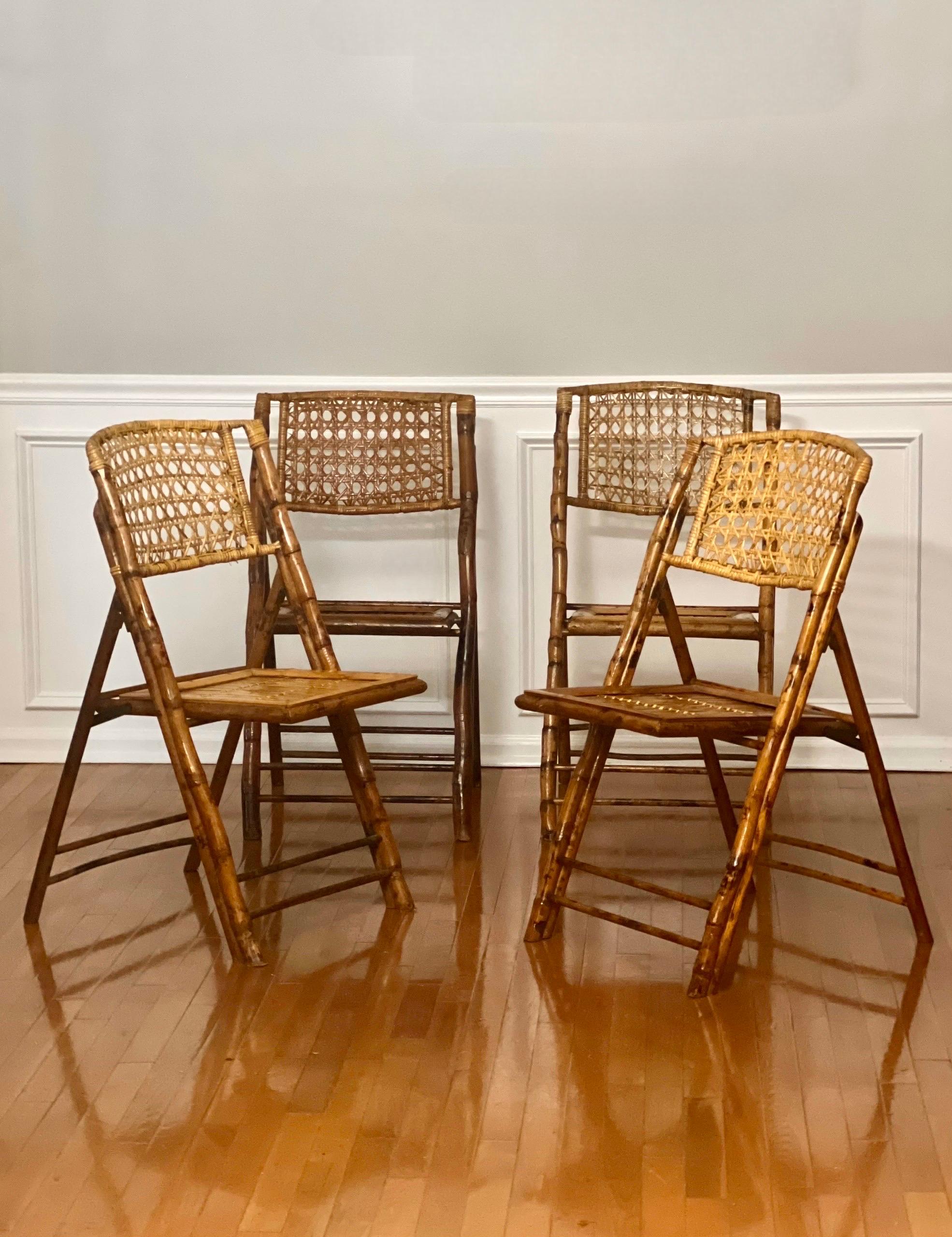 Beautiful set of four vintage tortoise shell burnt bamboo folding chairs. Great for extra side seating or dining chairs featuring an open weave rattan cane seat back and a space-saving folding design. Attractive and well-constructed chairs in good,