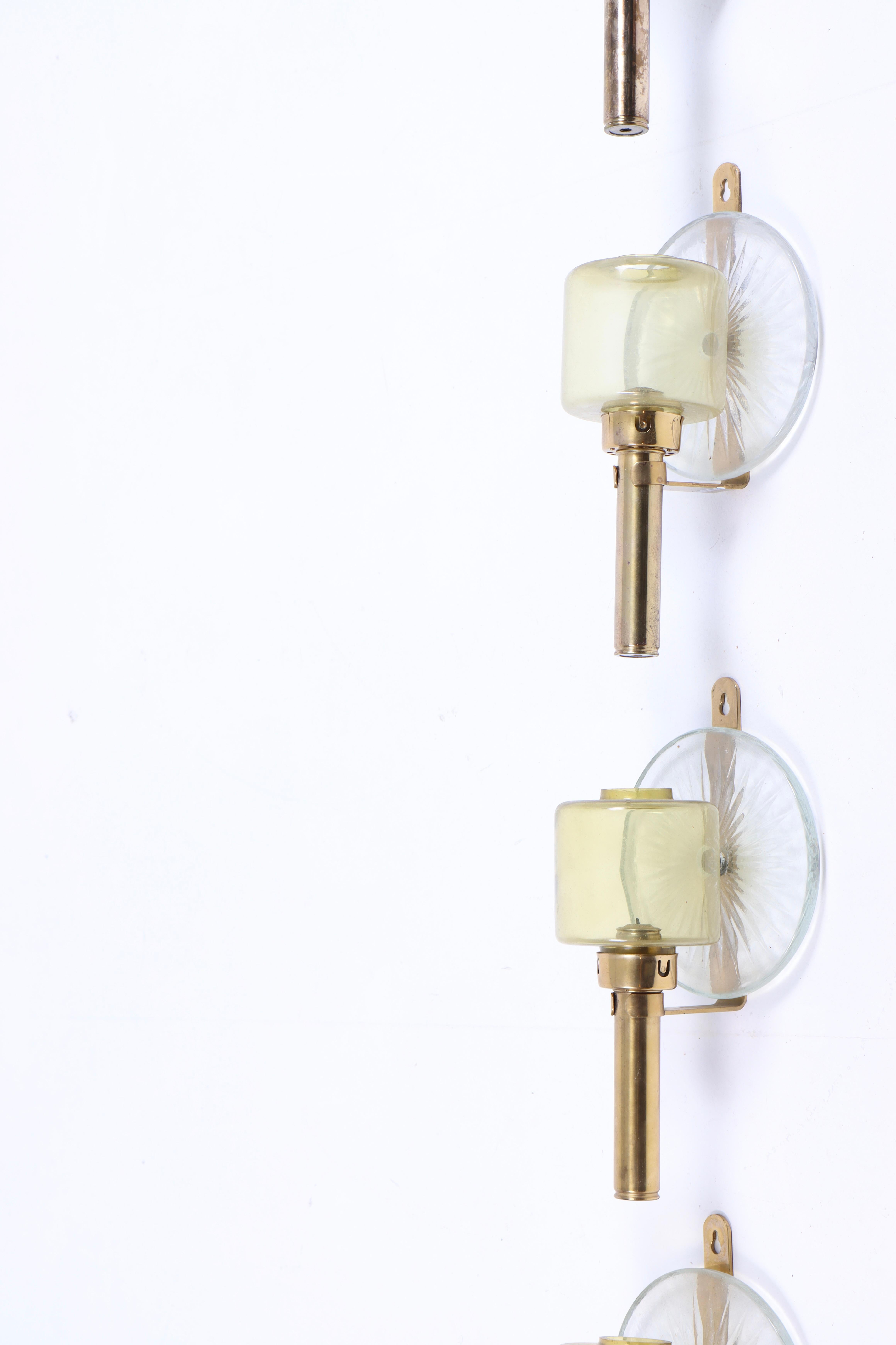 Set of four wall candelabras in brass and glass. Made in Sweden 1950s.