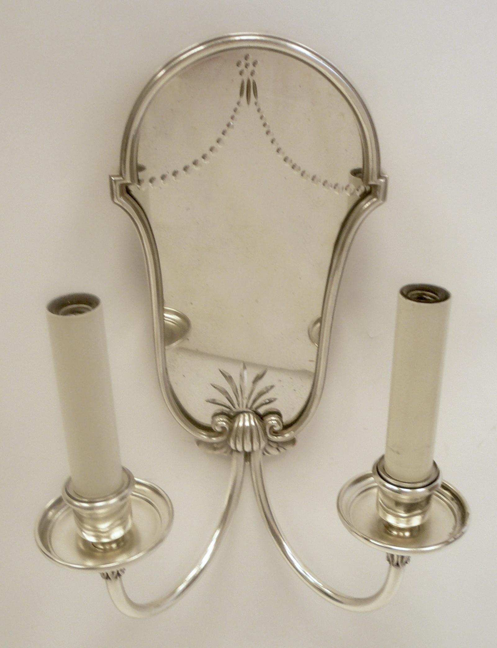 This set of four Caldwell sconces have cartouche shaped mirrored backs with wheel cut designs.