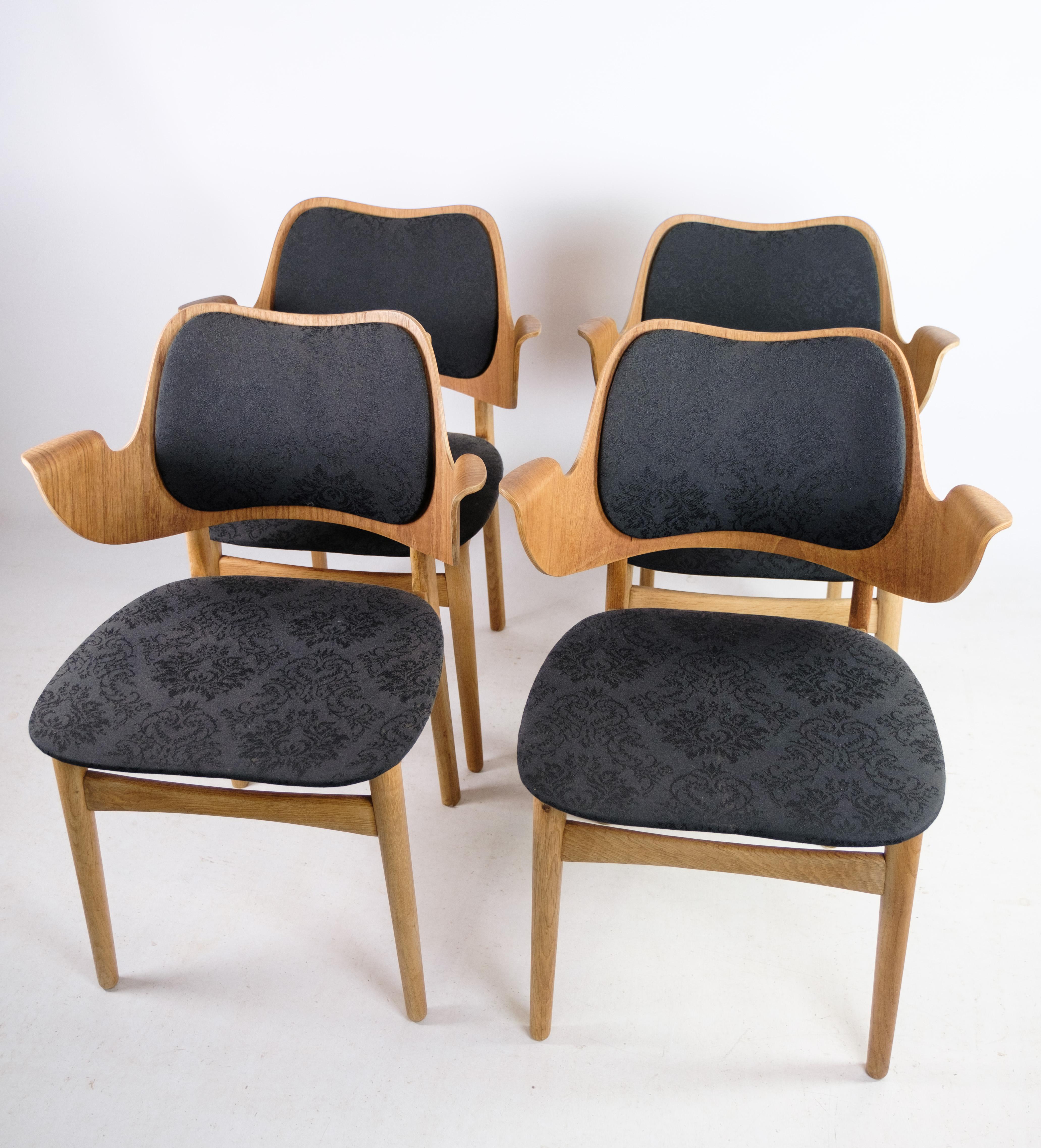 This set of four armchairs, model 107, designed by Hans Olsen for Bramin around the 1960s, showcases the iconic Danish design aesthetic of the era. Crafted from a combination of oak and teak, these chairs exemplify the natural beauty and durability