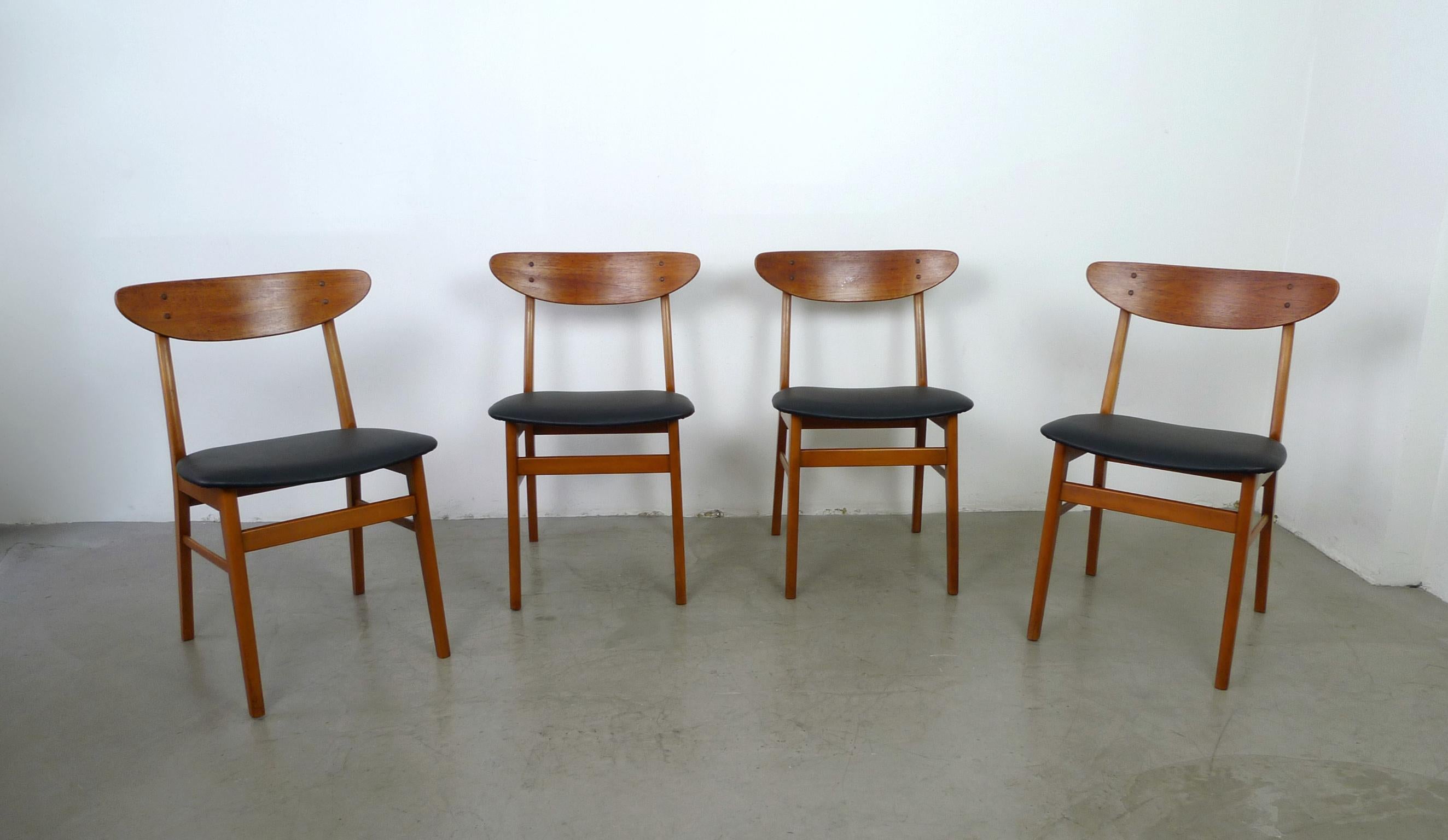 This set of four model 210 dining chairs by Farstrup was made in the 1960s in Denmark. The frame is made of beech wood and the back is made of teak. The seats are newly covered with black imitation leather.