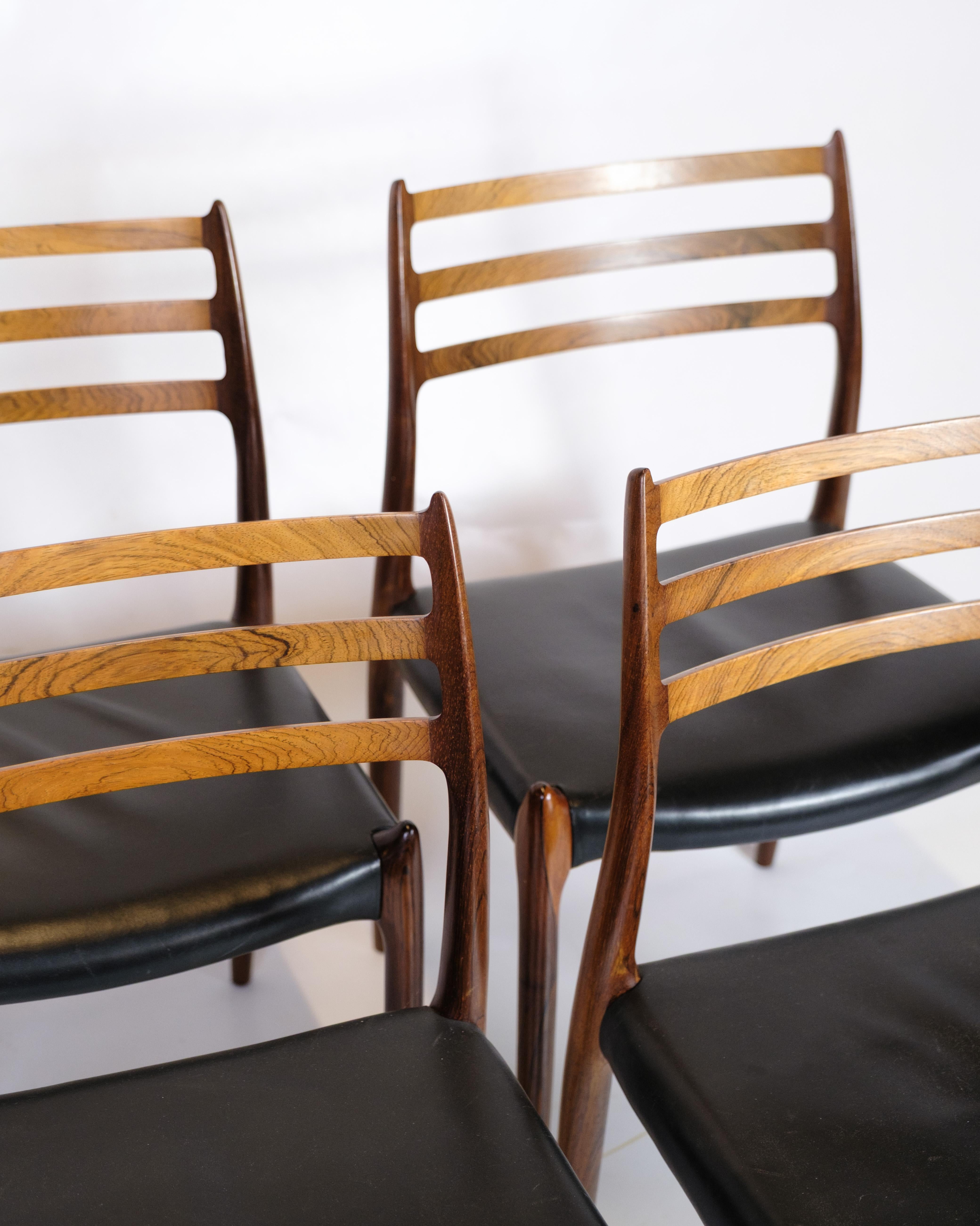Ensemble de quatre chaises de salle à manger en bois de rose massif, conçu par Niels O. Møller et fabriqué par I.L.A. Møllers Møbelfabrik dans les années 1950. Les fauteuils sont recouverts de cuir noir et possèdent le dossier caractéristique à