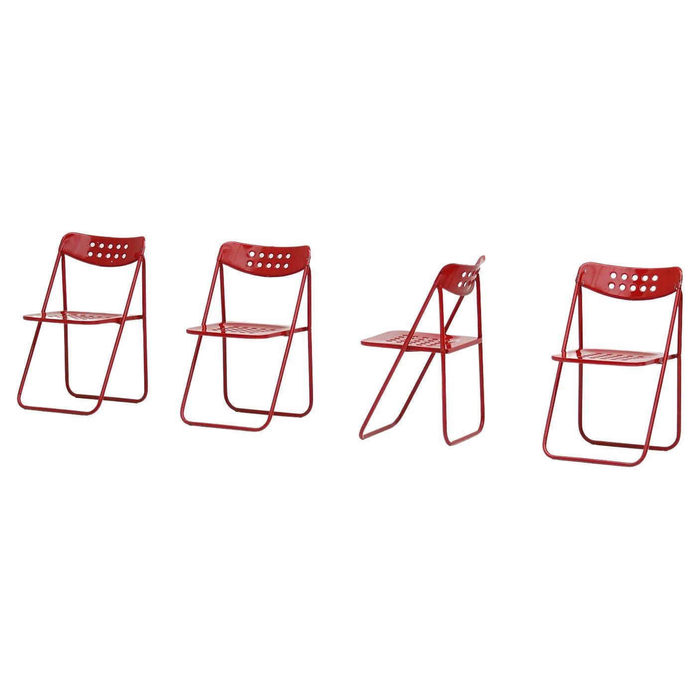 Ensemble de quatre chaises pliantes modernes en métal laqué rouge des années 1980