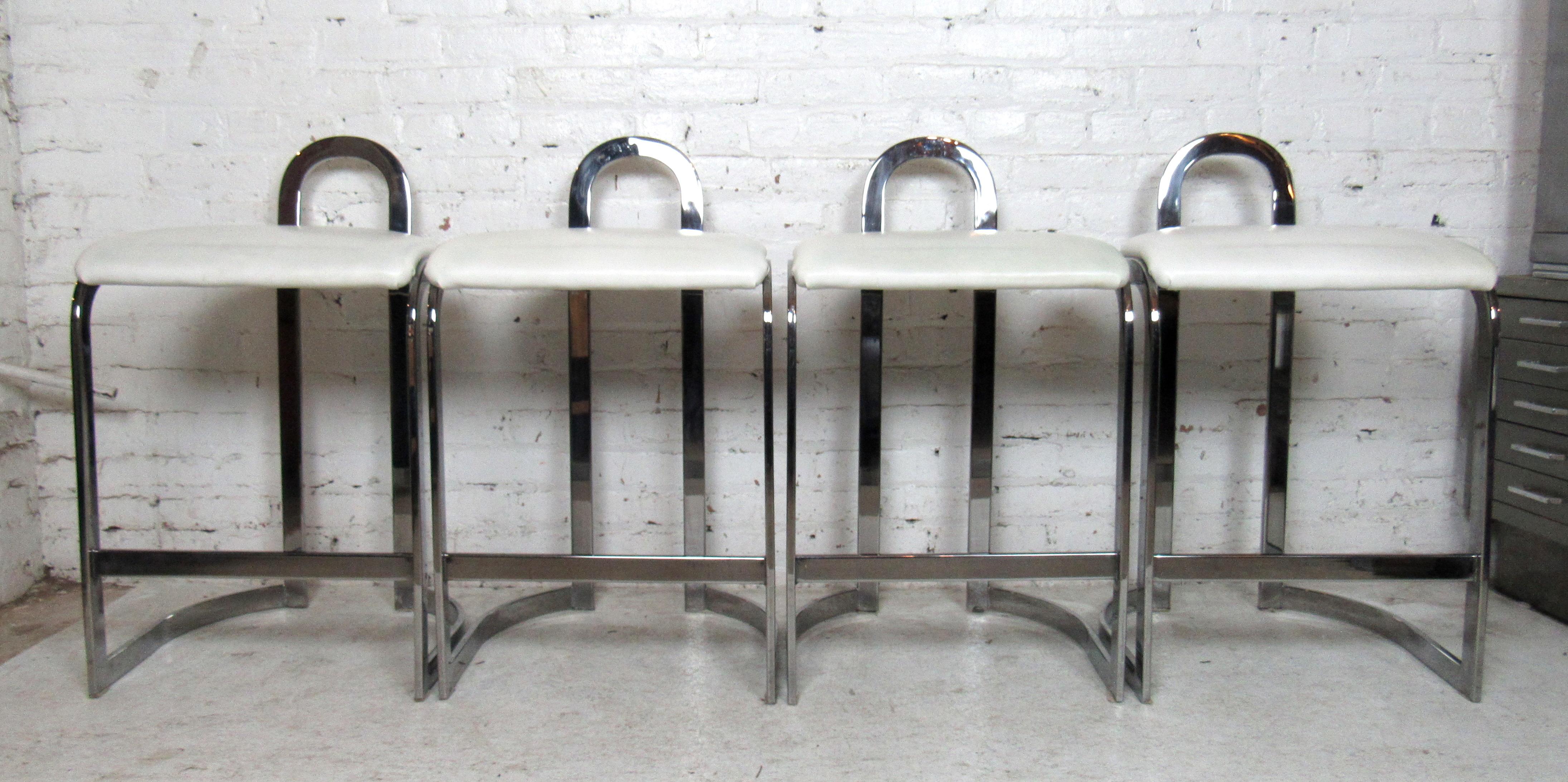 Set of four vintage modern style chrome counter stools featuring white vinyl seating.

Please confirm item location with dealer (NJ or NY).