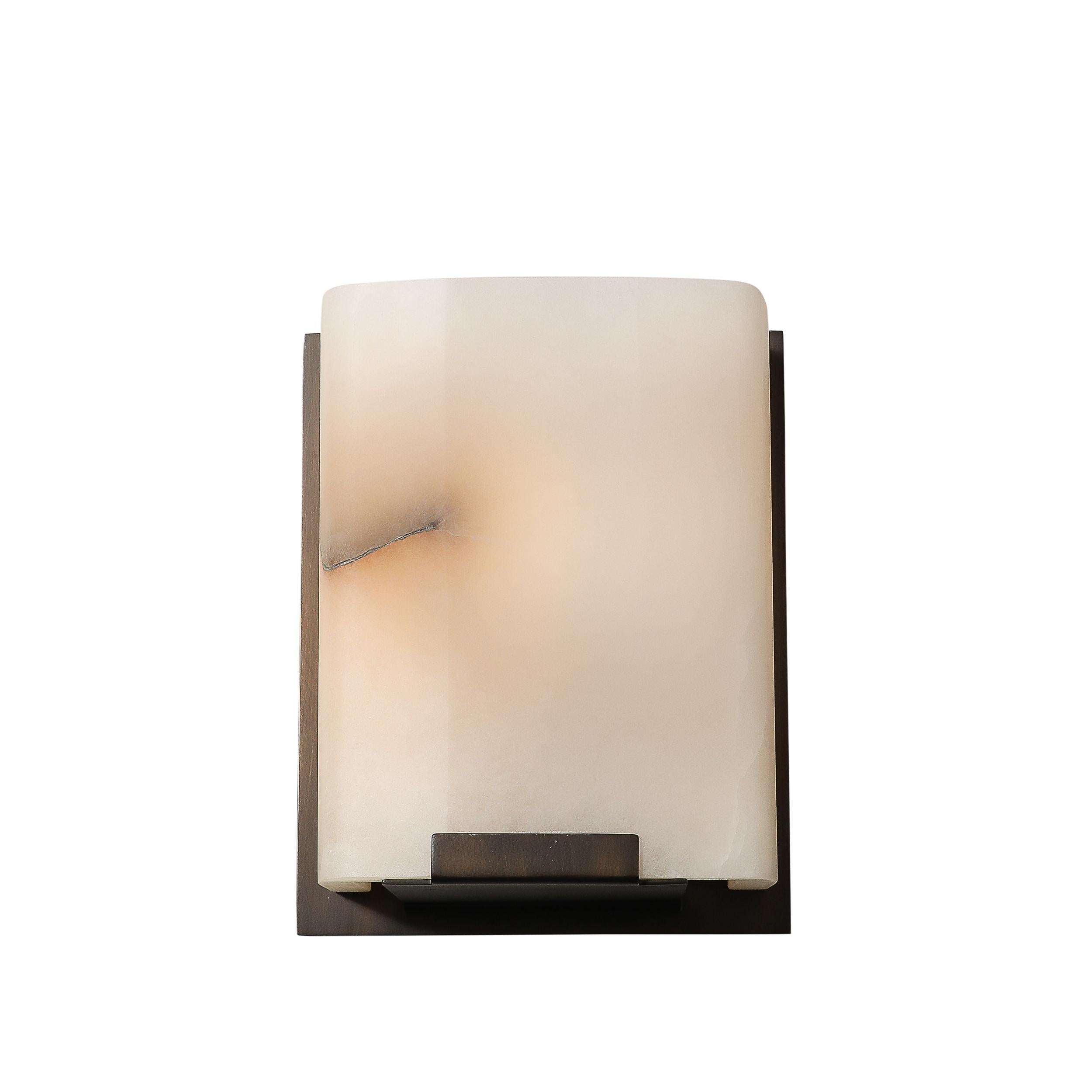 Verschönern Sie Ihr Zuhause mit diesem Set aus vier modernistischen Wandleuchtern aus Alabaster und ölgeriebener Bronze, die in den Vereinigten Staaten im 20. Jahrhundert mit Präzision gefertigt wurden. Diese Wandleuchten vereinen Schlichtheit und