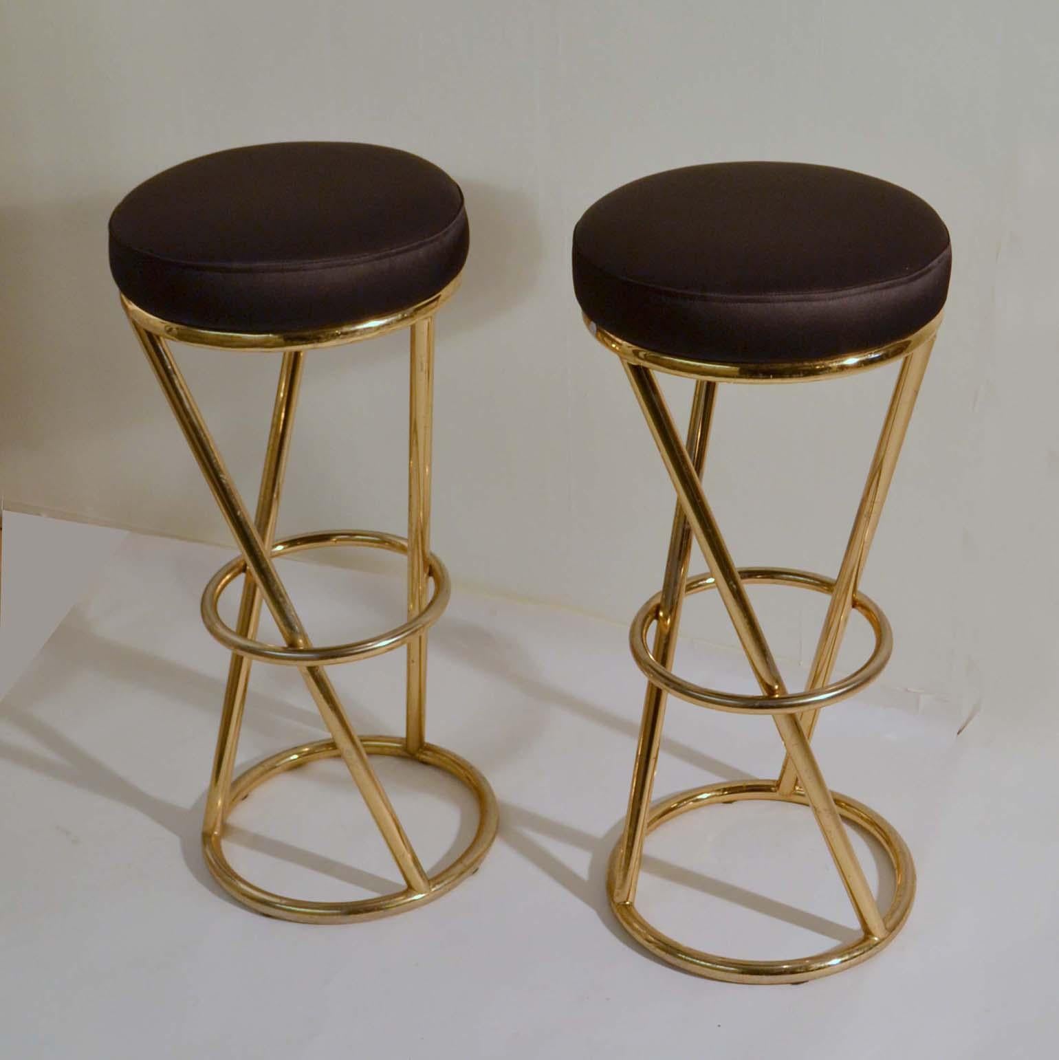 Circular bar stools have tubular brass plated metal frames. Designed by Pierre Chareau in the 1930s (Art Deco). This is a 1980s re-edition.
The seats are re-upholstered in black satin. They are very comfortable and sturdy.