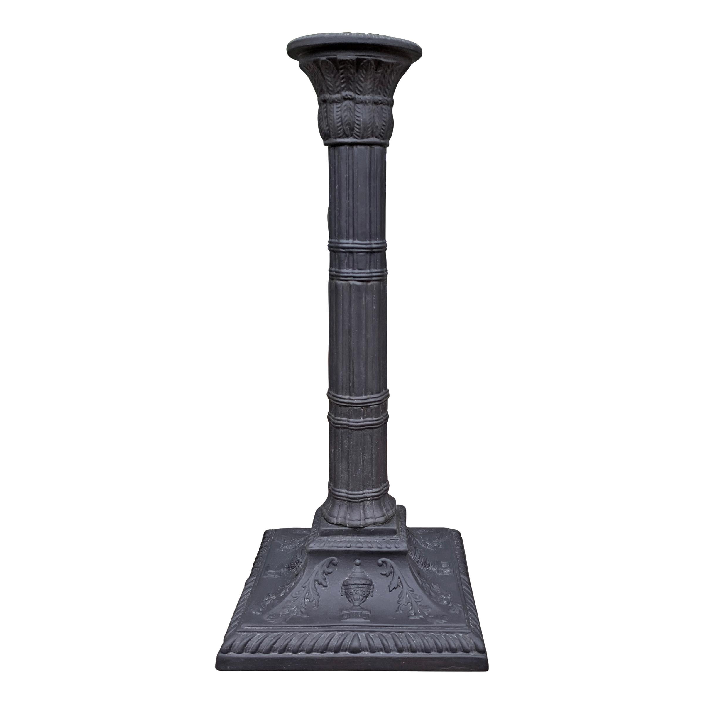 A set of four mid-20th century Italian Mottahedeh basalt candlesticks of classical form with quasi-Egyptian motif including reeded columns with papyrus leaf capitals, all on a square raised platform with acanthus leaves and urns on each side.