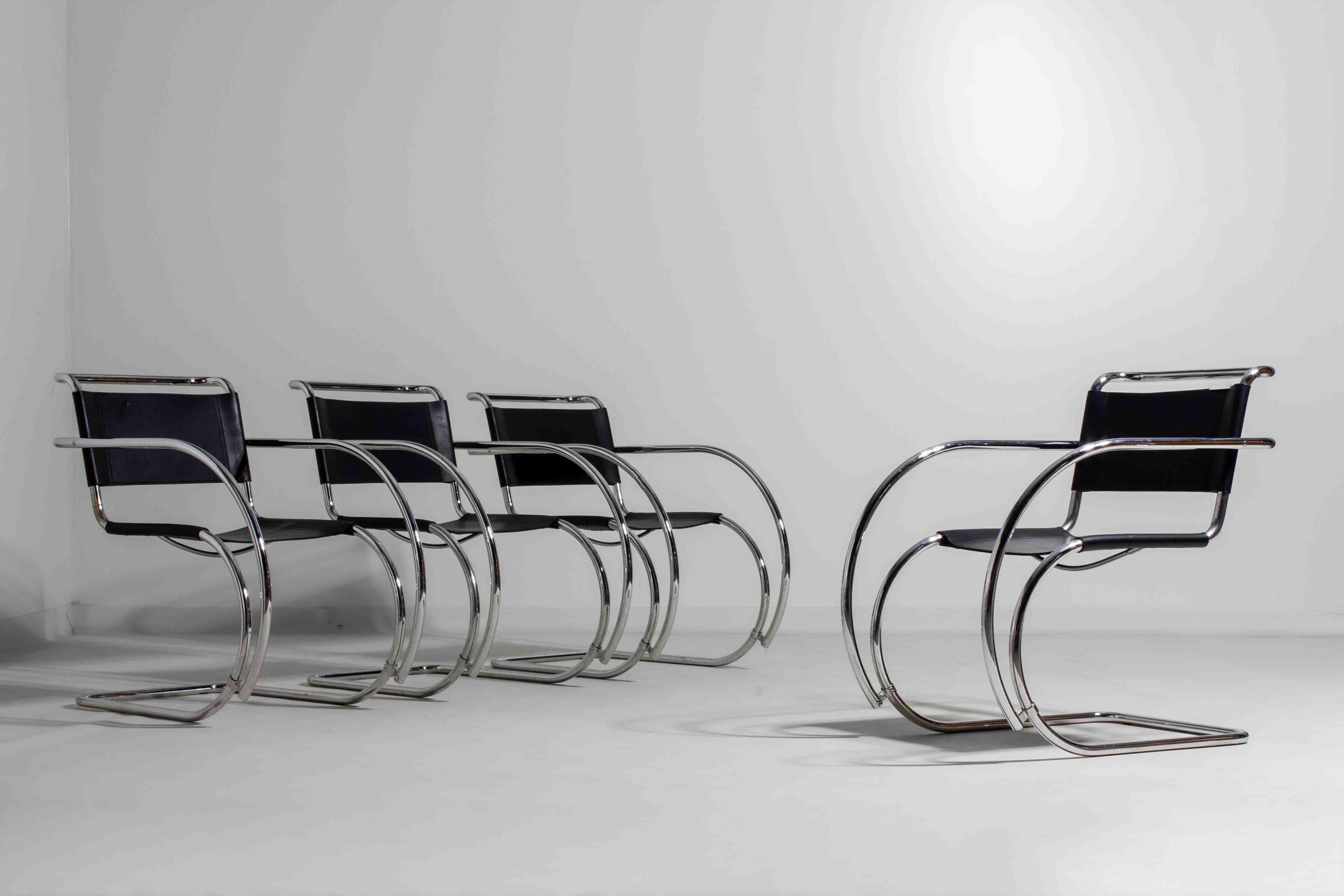 Set di quattro sedie a sbalzo Bauhaus, realizzate negli anni '70 sulla base dell'iconico design MR20 di Ludwig Mies van der Rohe. Le sedie sono caratterizzate da una fluida struttura tubolare cromata e da sedili a fascia neri, che uniscono il