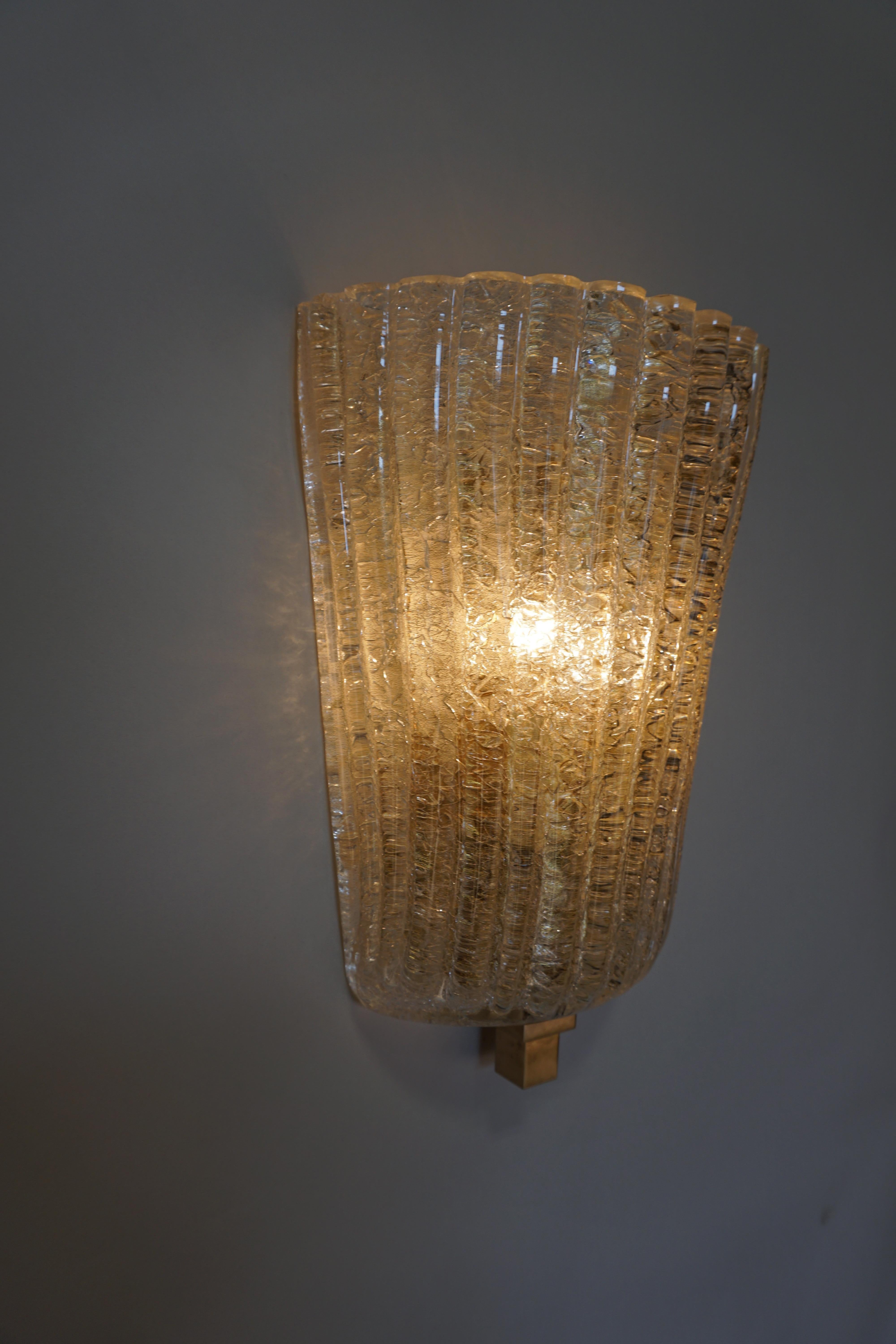 Set of four clear with touch of gold blown glass with crushed ice texture inside wall sconces.
Two-light 60 watt each.