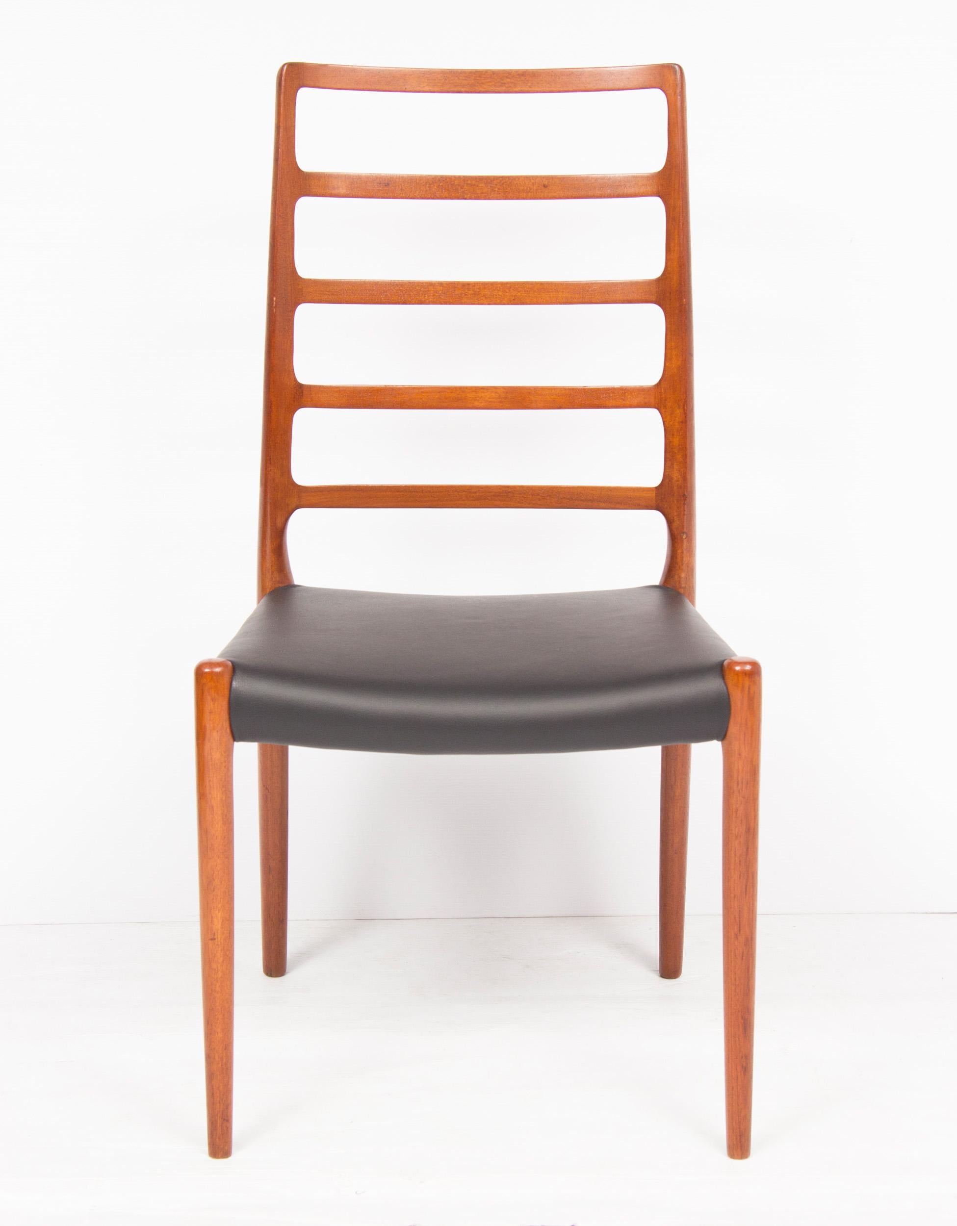 A set of four rare Niels O. Møller for J.L. Møller Model #82 Teak ladder-back dining chairs with newly reupholstered black leather seats. A comfortable, sculptural, high back dining chair with five rungs across their backs for full support. In very