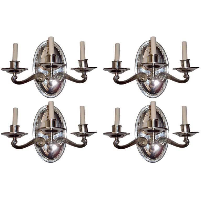 Set of four English circa 1920s silver plated three-light sconces with beaded detail around large oval backplate and original patina. Sold per pair.

Measurements:
Height 12.25