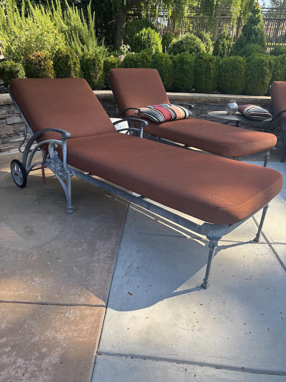 Set of four beautifully detailed cast Aluminum Patio Chaise Longues by Molla Foundry. The Chaises feature their original patinated Verdigris finish along with rubber tires. The quick-dry foam cushions are authentic Sunbrella Brick Red. Please