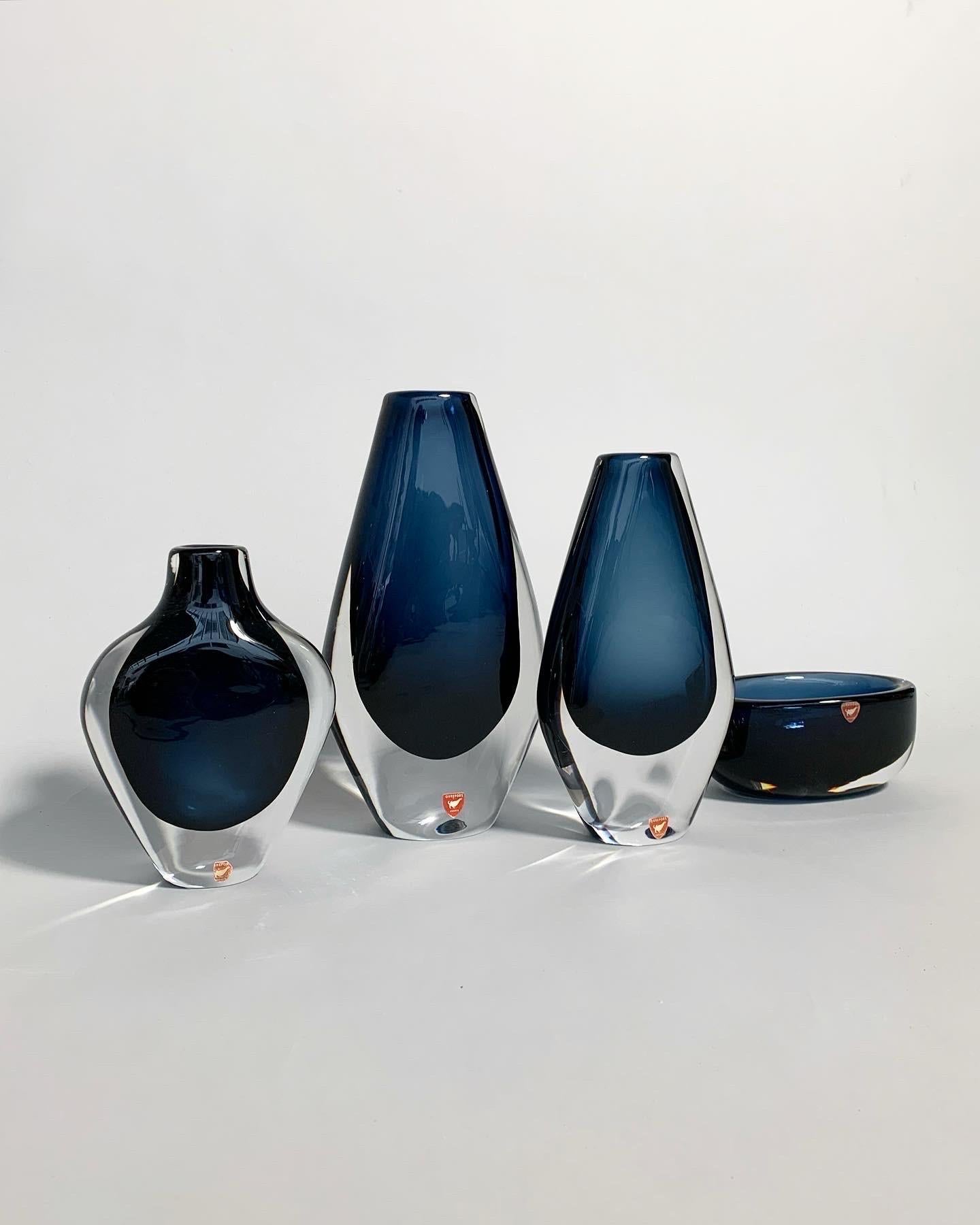 Stunning set of Nils Landberg vases in midnight blue, mouth-blown at Orrefors glassworks in Sweden in the early 1960s. 
Hand-crafted and signed underneath. 

Height: 24.5 cm, 21 cm, 16.5 cm, 6 cm
Width: 12 cm, 11 cm, 12 cm, 14 cm
Depth: 5.5 cm,