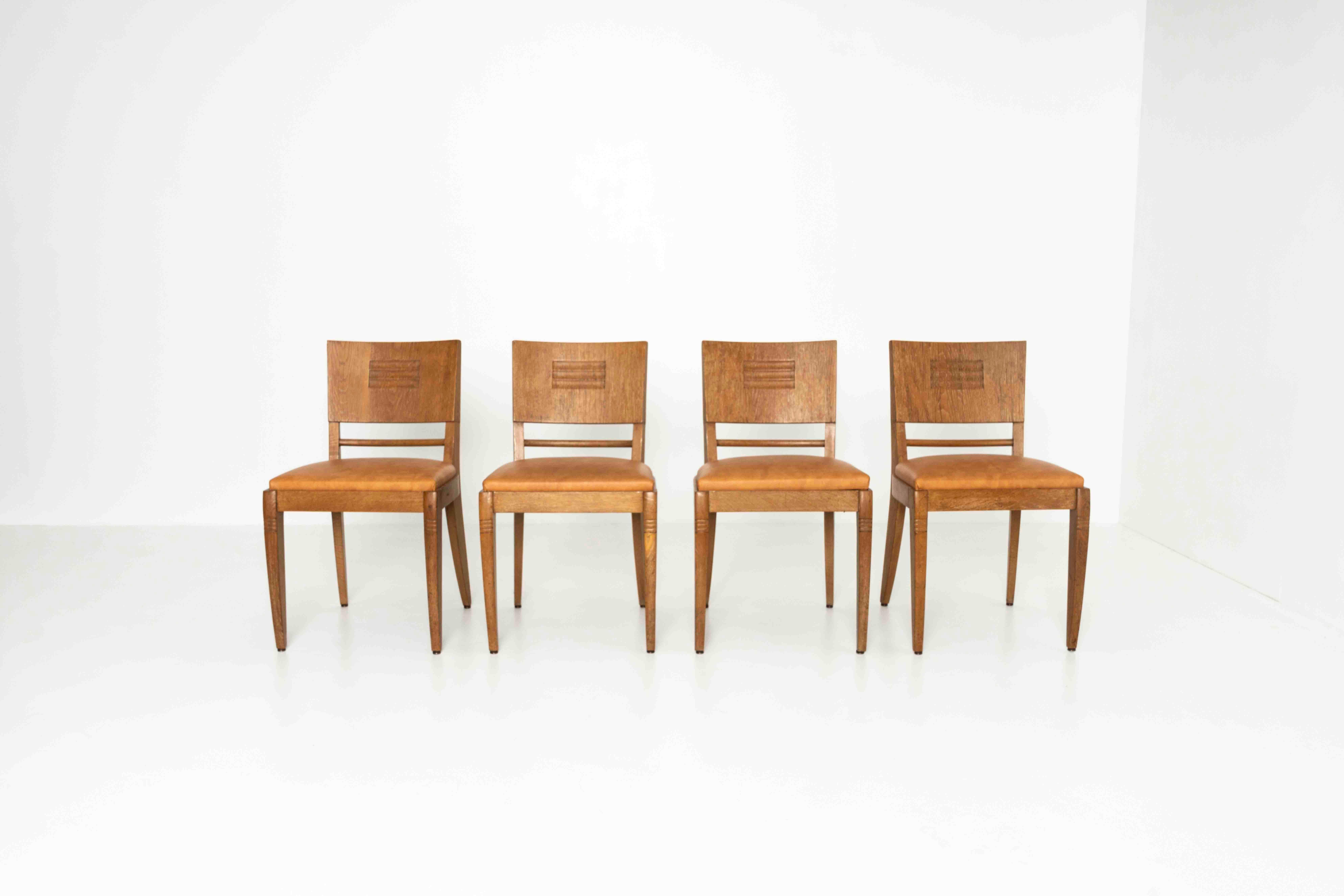Ensemble de quatre chaises de salle à manger en chêne avec des sièges en cuir de France, très probablement des années 1950. Le style nous rappelle les dessins de Guillerme et Chambron avec un design très rustique et robuste. Les chaises sont en bon