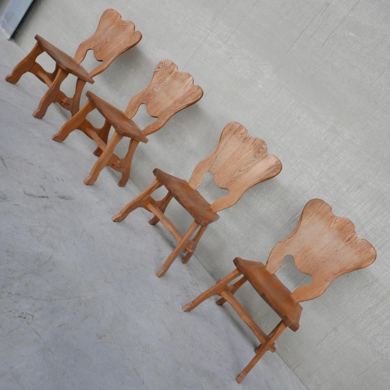 A set of four generous oak dining chairs. 

Belgium, c1970s. 

Solid wood. Decorative back rests paired with nice pegged detailing to the base. 

Good condition, some scuffs commensurate with age. 

Location: Belgium Gallery. 

Dimensions: