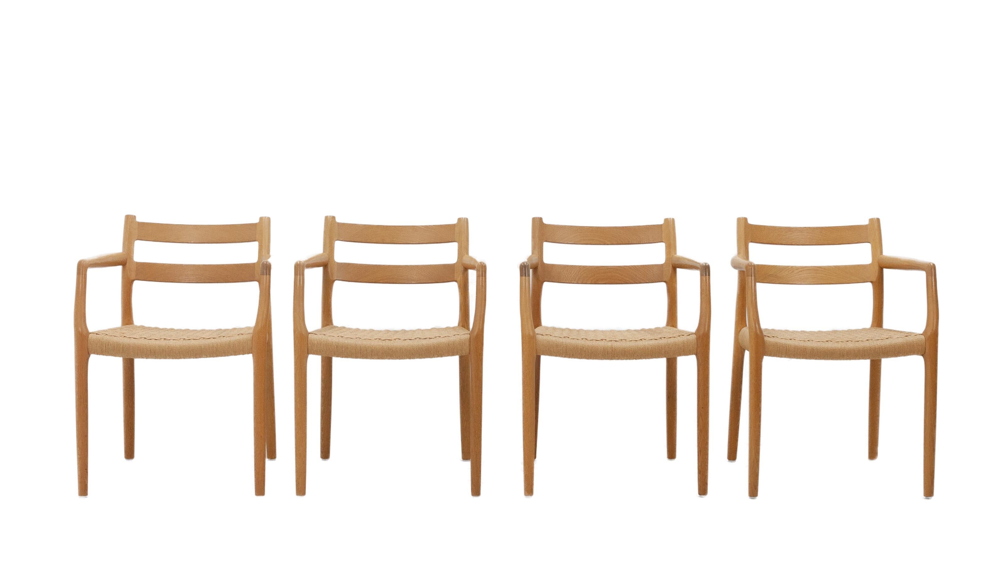 Four Niels Moller model 67 chairs designed by Niels Otto Moller for J.L. Moller, 1970s. These chairs are one of the J.L. Moller company's landmark designs. They feature two curved support strips across the backrest, gracefully sculpted arm rests and