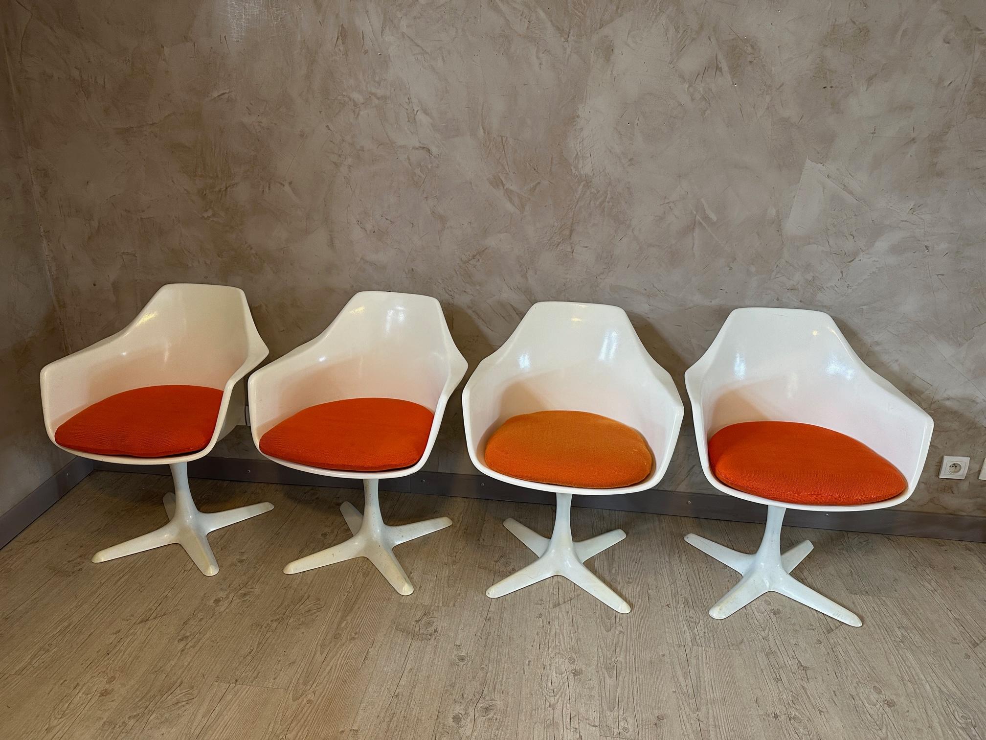 Set of 4 swivel armchairs from the 60s designed by Maurice Burke for Arkana furniture.
Inspired by Eero Saarinen's tulip chairs.
Fiberglass seats with a powder coated steel 4 point star base.
Original orange cushions (a little fading) 
Superb