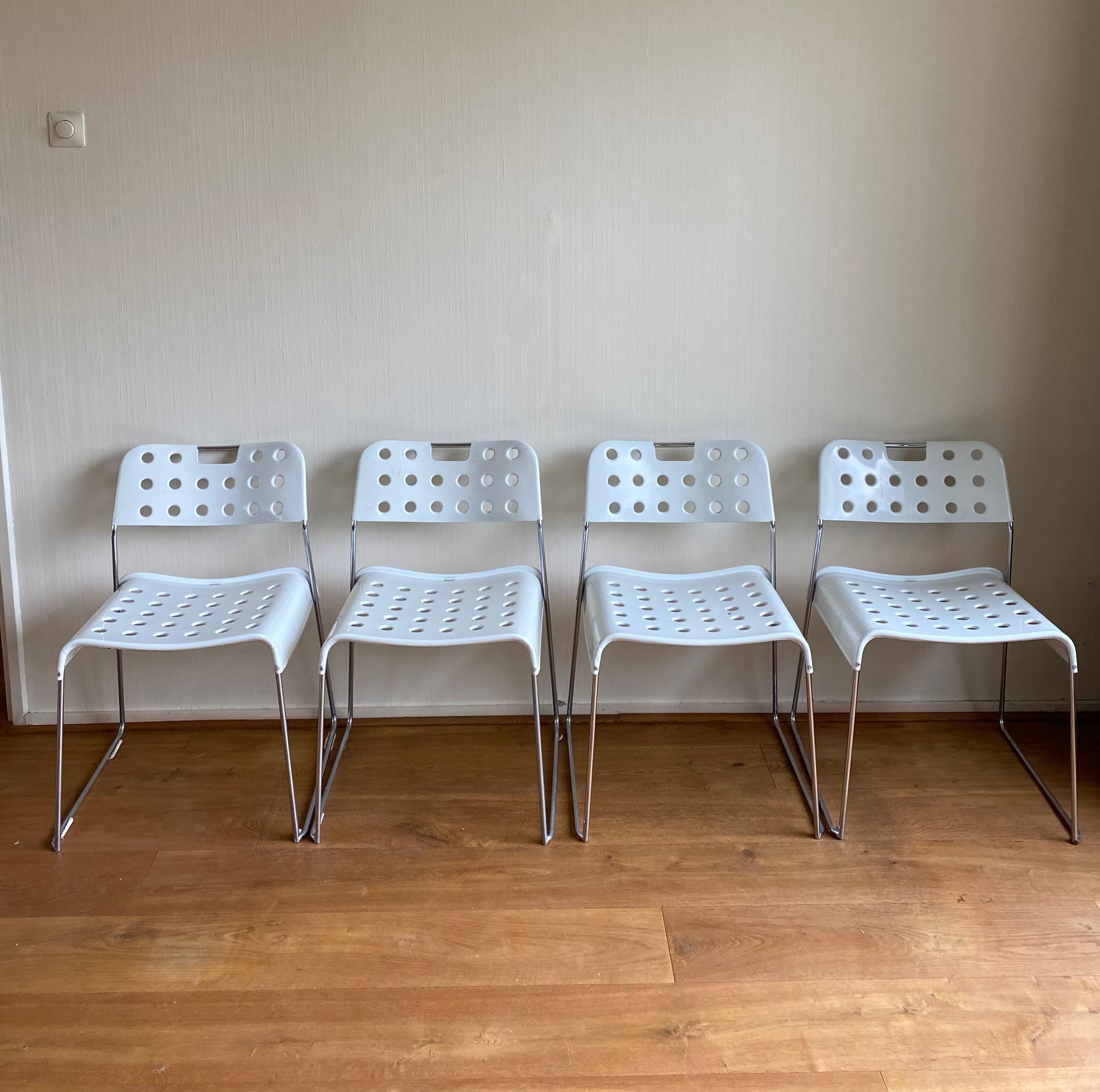 Set of four white chairs, Model Omkstak, Designed by Rodney Kinsman for Bieffeplast Italy. The chairs feature a Peforated Metal Base With Chromed feet. Very nice and uncommon Italian Design. The chairs show some wear, consisting with age and use