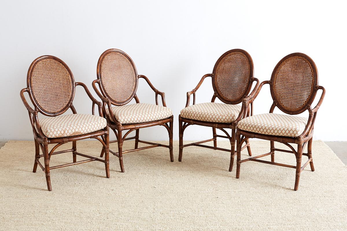Handsome set of four organic modern armchairs by McGuire. Constructed from hand-crafted rattan frames reinforced with leather rawhide strapping. Features a caned seat and back the latter having a double panel of cane. Excellent condition with tight