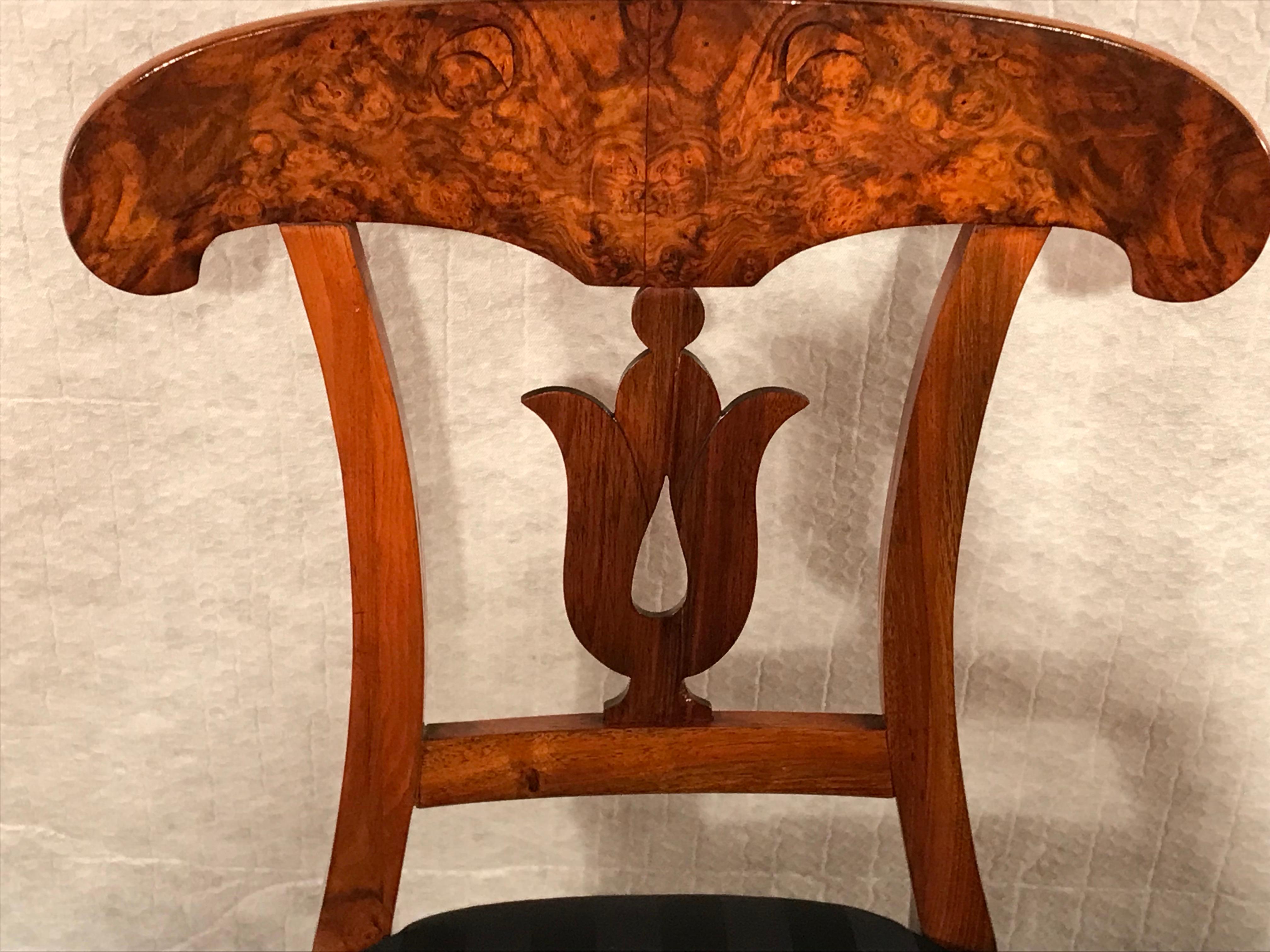 This set of four Biedermeier chairs dates back to 1820 and comes from Southern Germany. 
The beautiful walnut chairs stand out for their beautifully designed back, the so called 