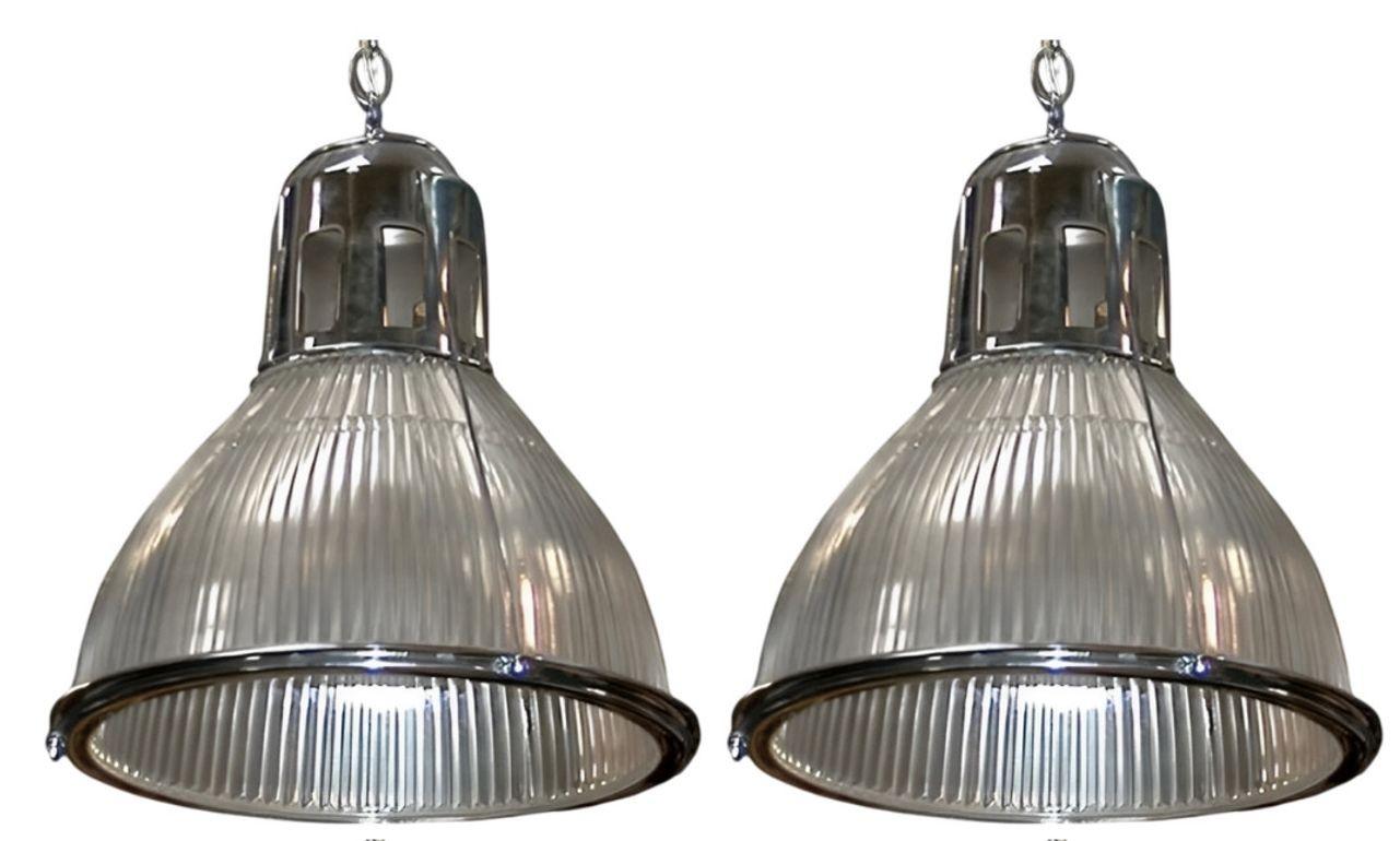 A stunning set of four original American 1920's Holophane pendant light fixtures featuring classic glass shades and their original nickel-plated hardware. Known for their timeless industrial style and exceptional light diffusion, Holophane lights