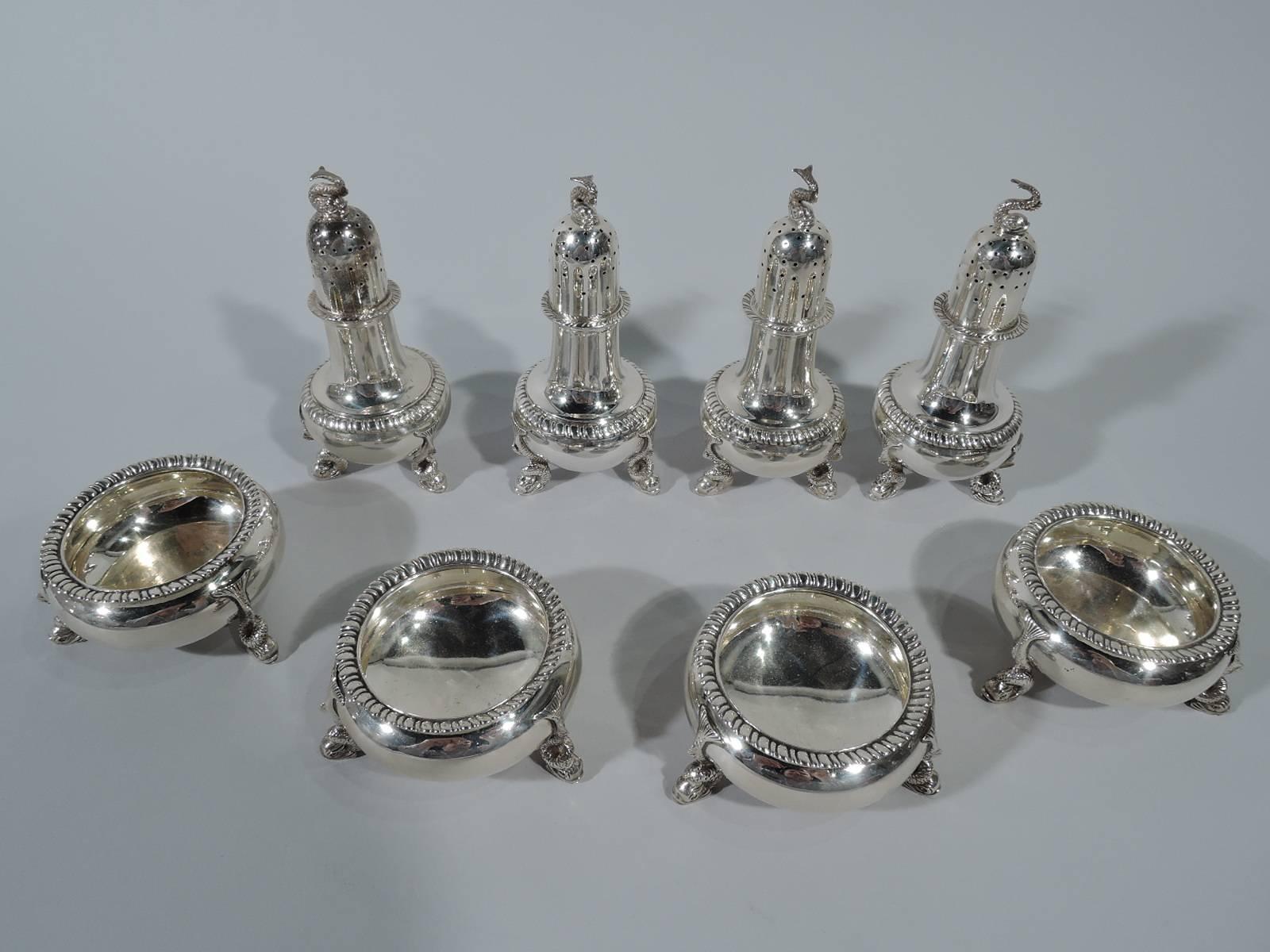Four pairs of sterling silver open salts and pepper shakers. Made by Tuttle in Boston, 1929-1930. Each salt: Bellied bowl with gadrooned rim and three dolphin supports. Each pepper: Baluster with pierced domed cover, gadrooning, and three dolphin