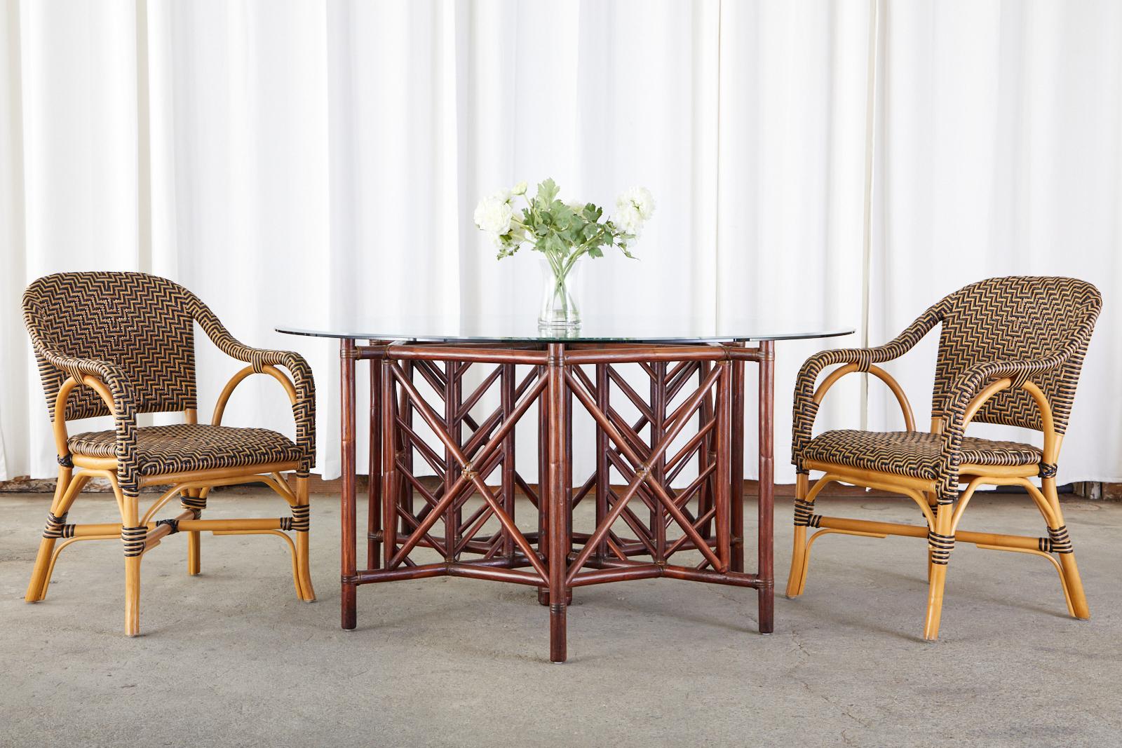 Delightful set of four bistro cafe style dining armchairs made by Palecek. The chairs feature a black and tan woven seat, back, and arms with a chevron/herringbone style design. Reminiscent of French art deco period designs with sinuous lines and
