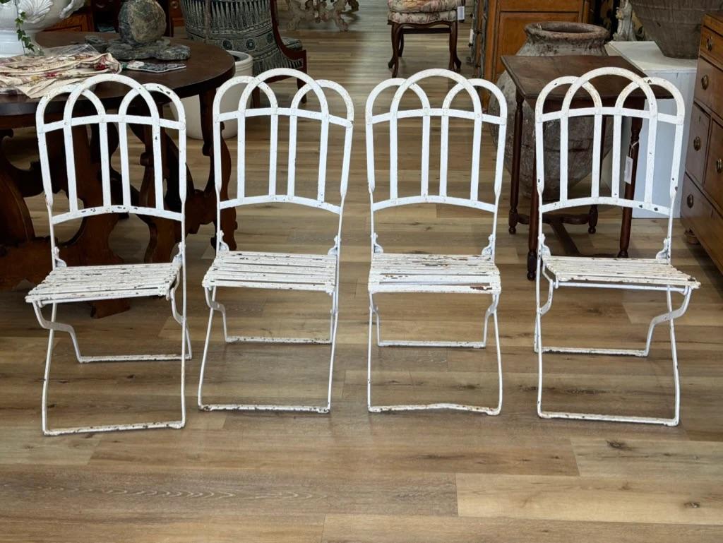 French cafe chairs, late 19th-early 20th Century.  Fabulous early chairs having attractive arching baks, heavy iron with iron-slat seats.  These do not fold.

