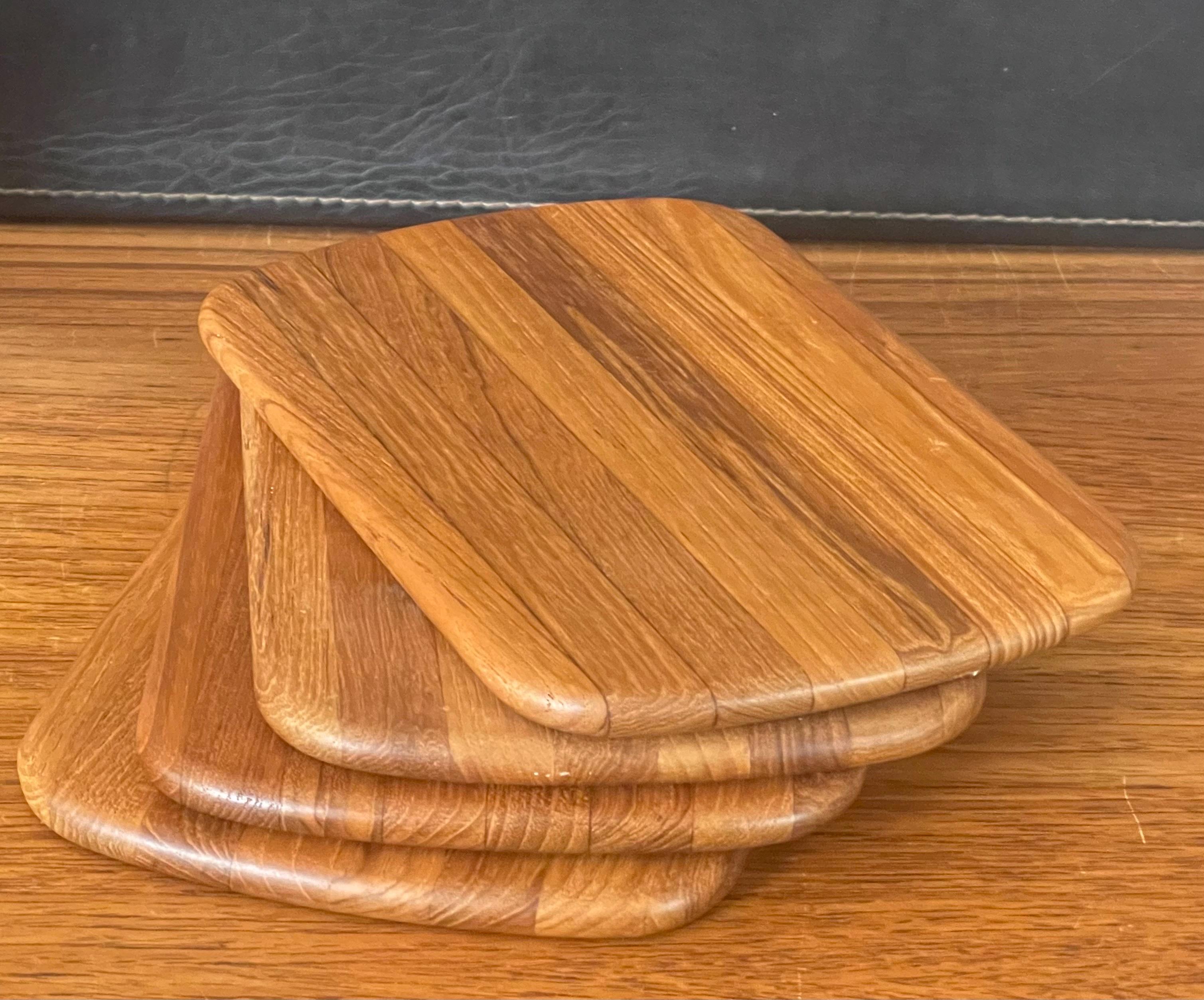 Set of four petite Danish modern teak butcher block cutting board / cheese tray with rounded edges, circa 1970s. The rectangle cutting boards are in great vintage condition (appear to be very lightly used, if at all) and measure 8.5