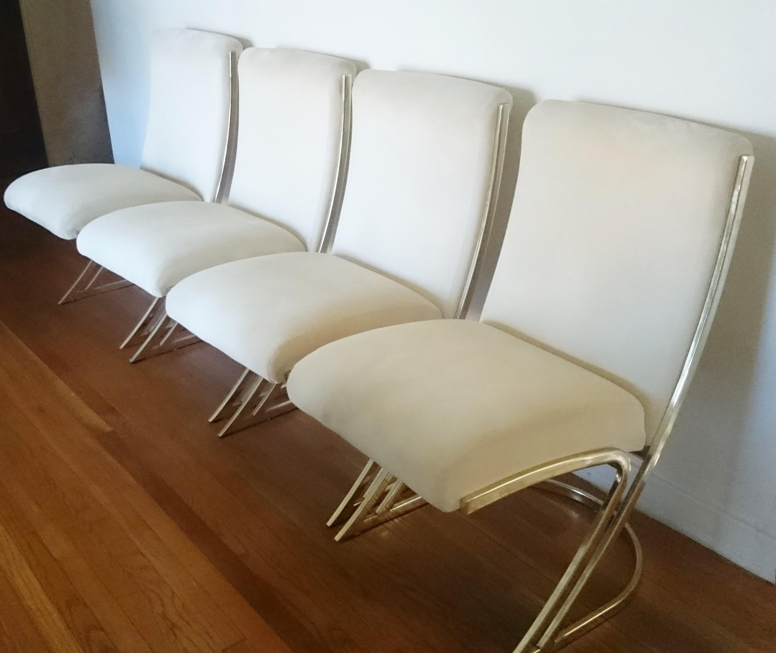 A stunning set of four Pierre Cardin dining chairs. Featuring plush cushioned new white upholstery supported by a sculptural cantilevered 