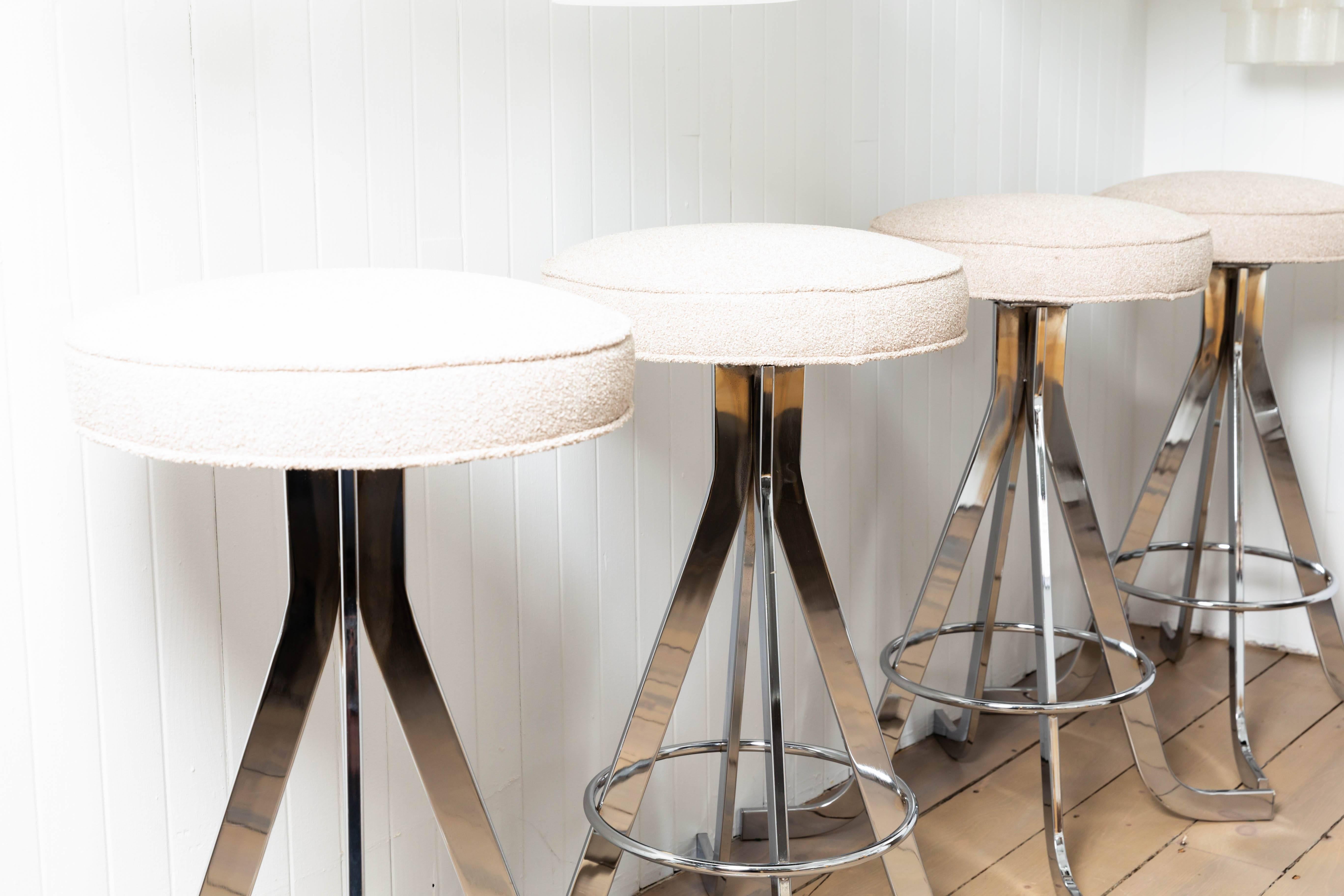 Set of four polished nickel stools with upholstered circular seats.