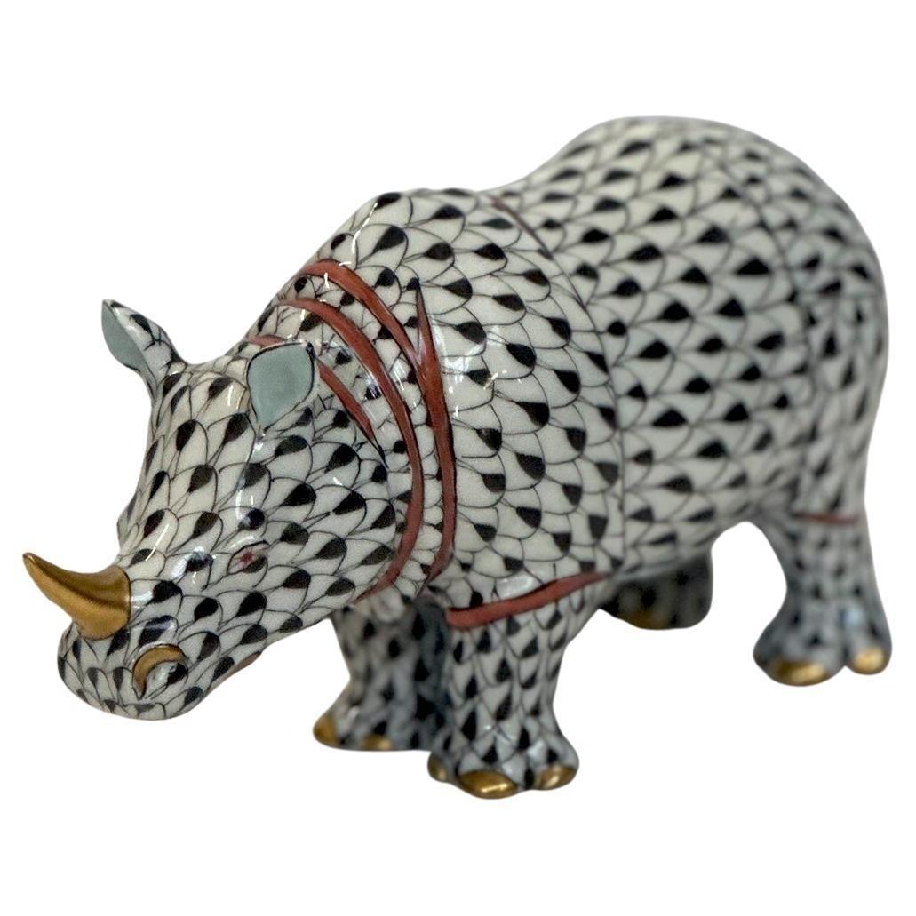 Colorful set of four hand-painted porcelain figurines by Herend Hungary, each adorned in the iconic fish scale pattern. The collection features a dog in vibrant green, white and gold accents, a rhino with black, white, gold and red details, an owl