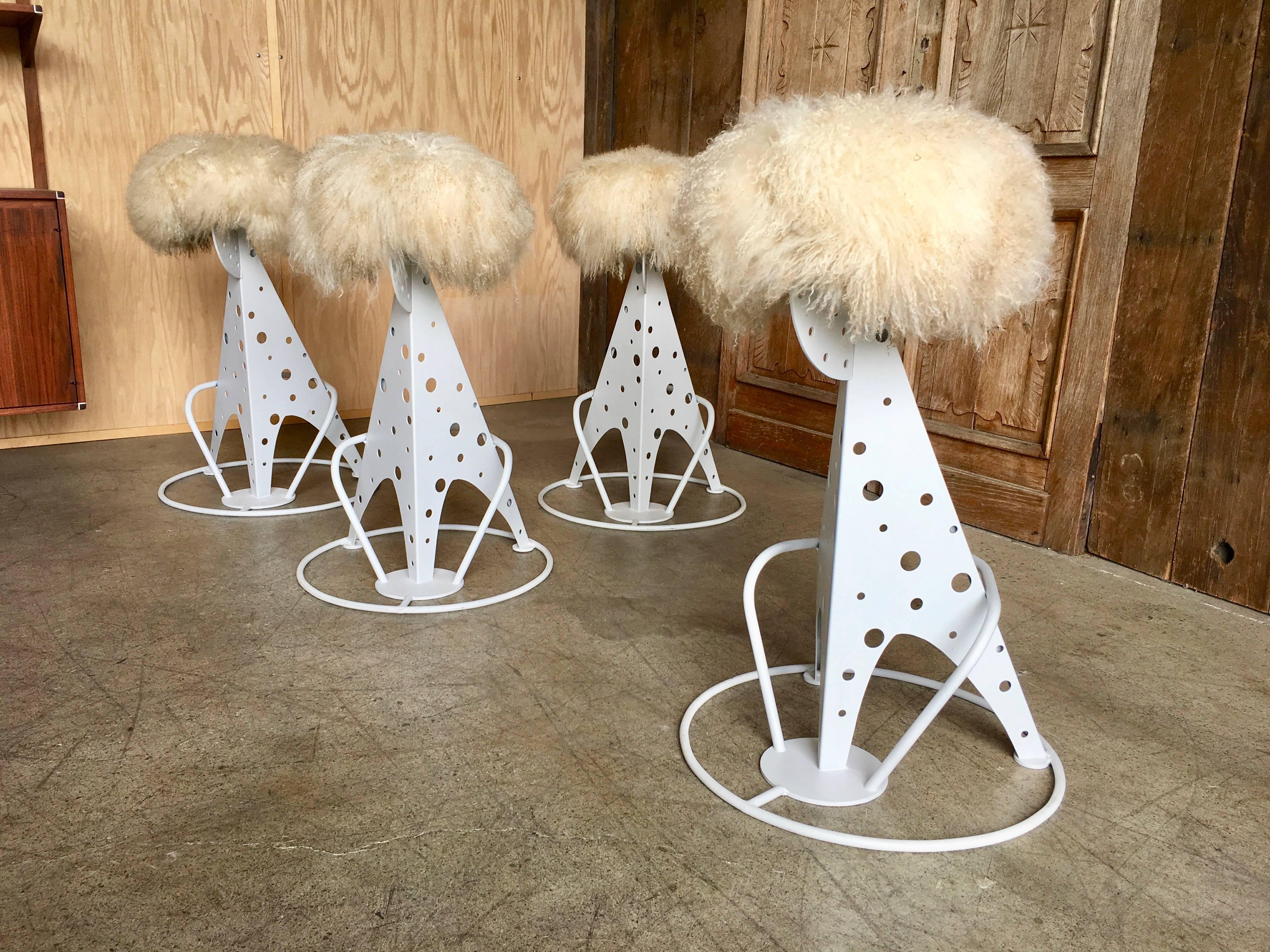 Set of four stools with cream color Mongolian lambs wool seats and satin white steel base.