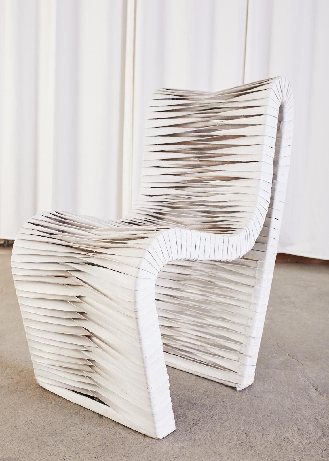 Aesthetic set of four sculptural lounge chairs featuring leather strap supports. The post modern chairs have a unique one piece steel frame that contours your body. Woven leather straps that are dyed white cover the frame with a decorative twist