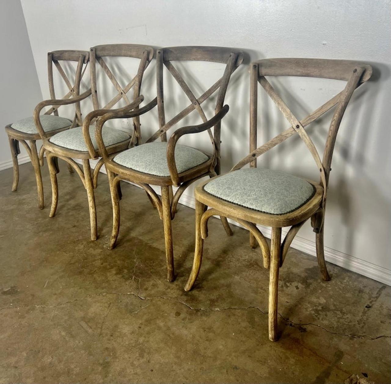 Set of four primitive style bleached oak dining chairs upholstered in a soft blue printed linen with nailheads.