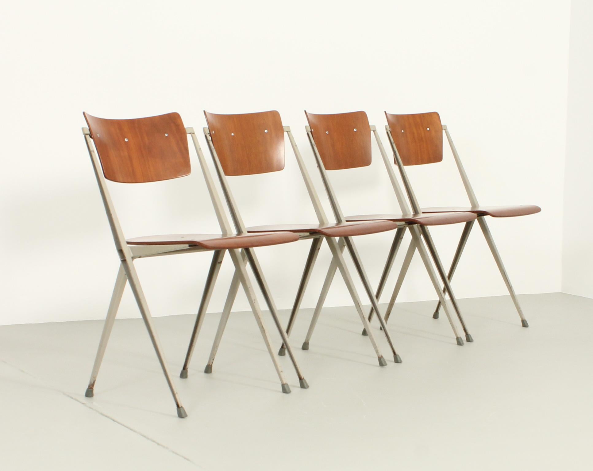 Set of four Pyramide chairs designed in 1964 by Wim Rietveld for De Cirkel, The Netherlands. Grey enamelled metal structure and teak wood. Stamped with the De Cirkel logo and dated from 1965.