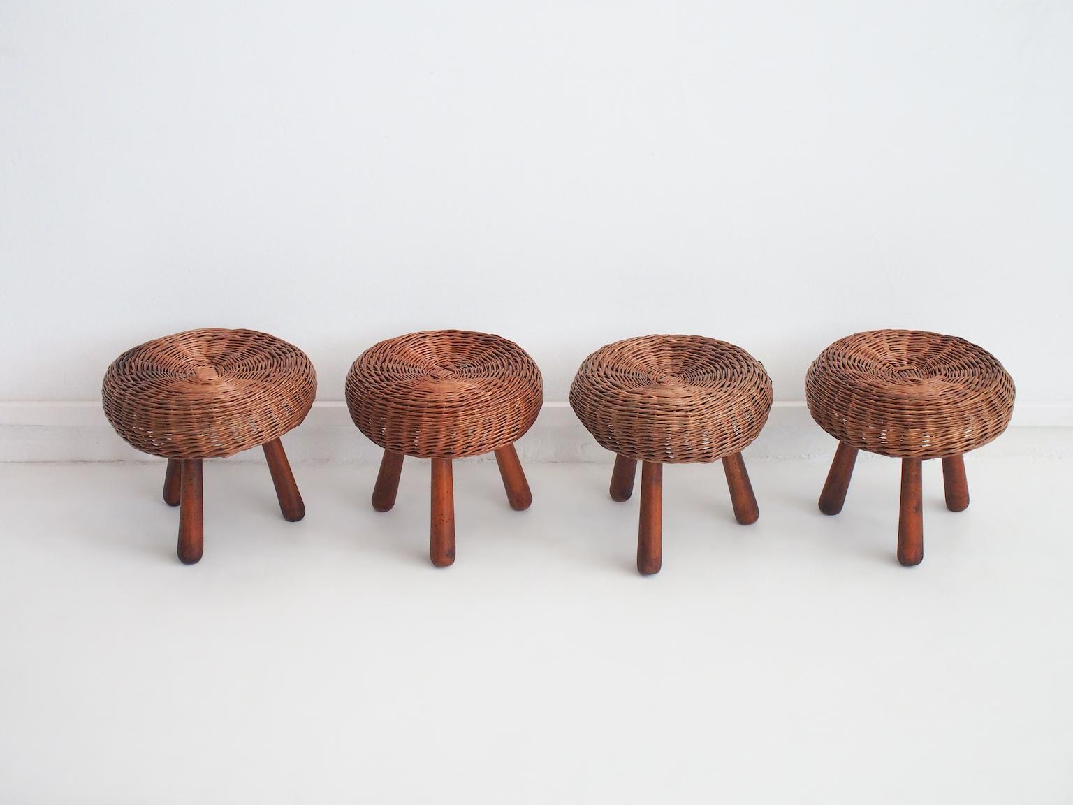 Set of four wicker stools designed by Tony Paul and produced in the United States in the '50s. These iconic sturdy stools feature a hand-woven rattan seat on top of three solid beech wood legs. Some age-related wear, darkening, scratches.