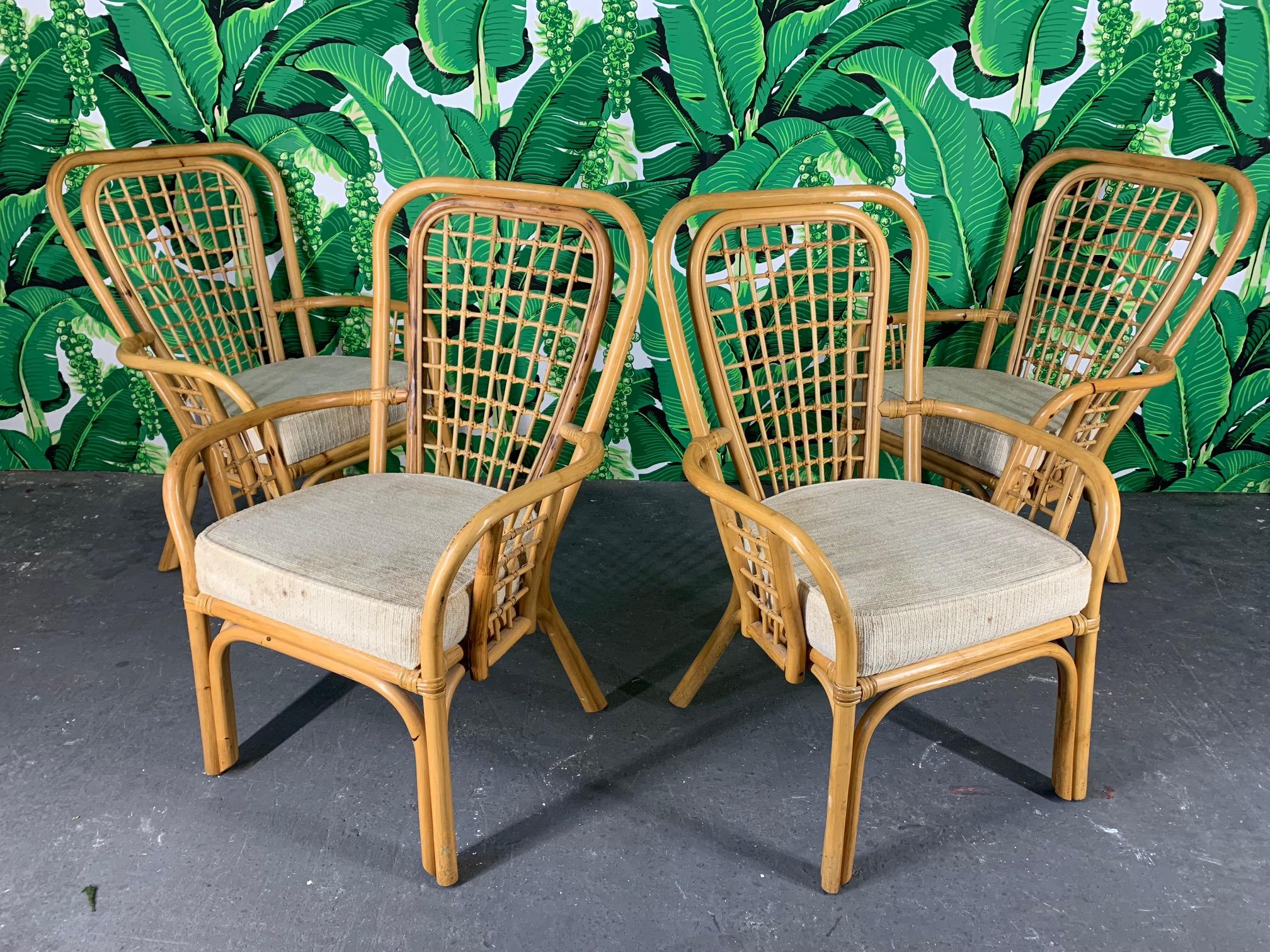 Set of 4 rattan dining chairs by Vogue Rattan feature a fan back design and thick, upholstered seats. Very good vintage condition with only minor signs of age appropriate wear.