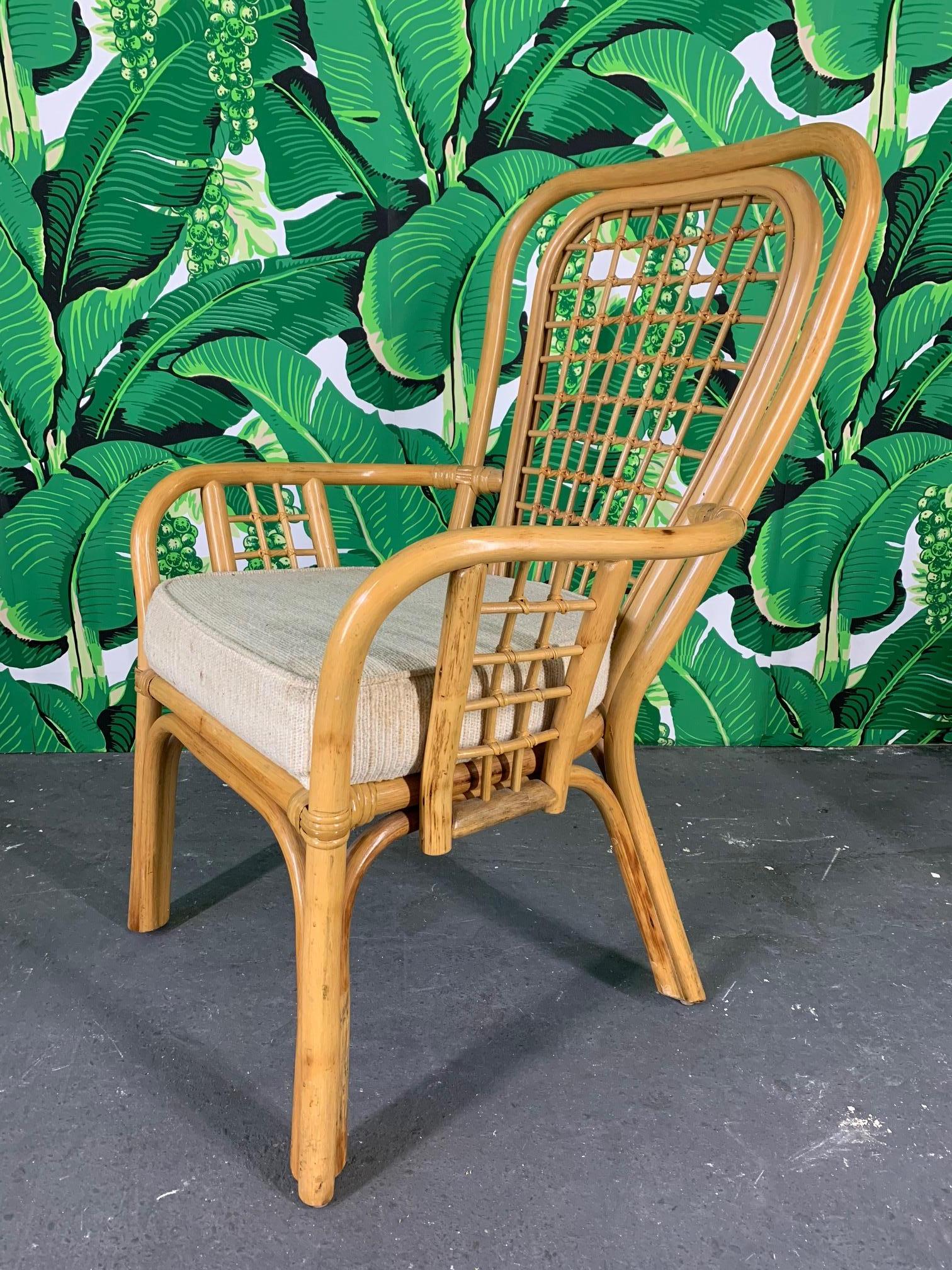 Set of 4 rattan dining chairs feature a fan back design and thick, upholstered seats. Very good vintage condition with only minor signs of age appropriate wear.