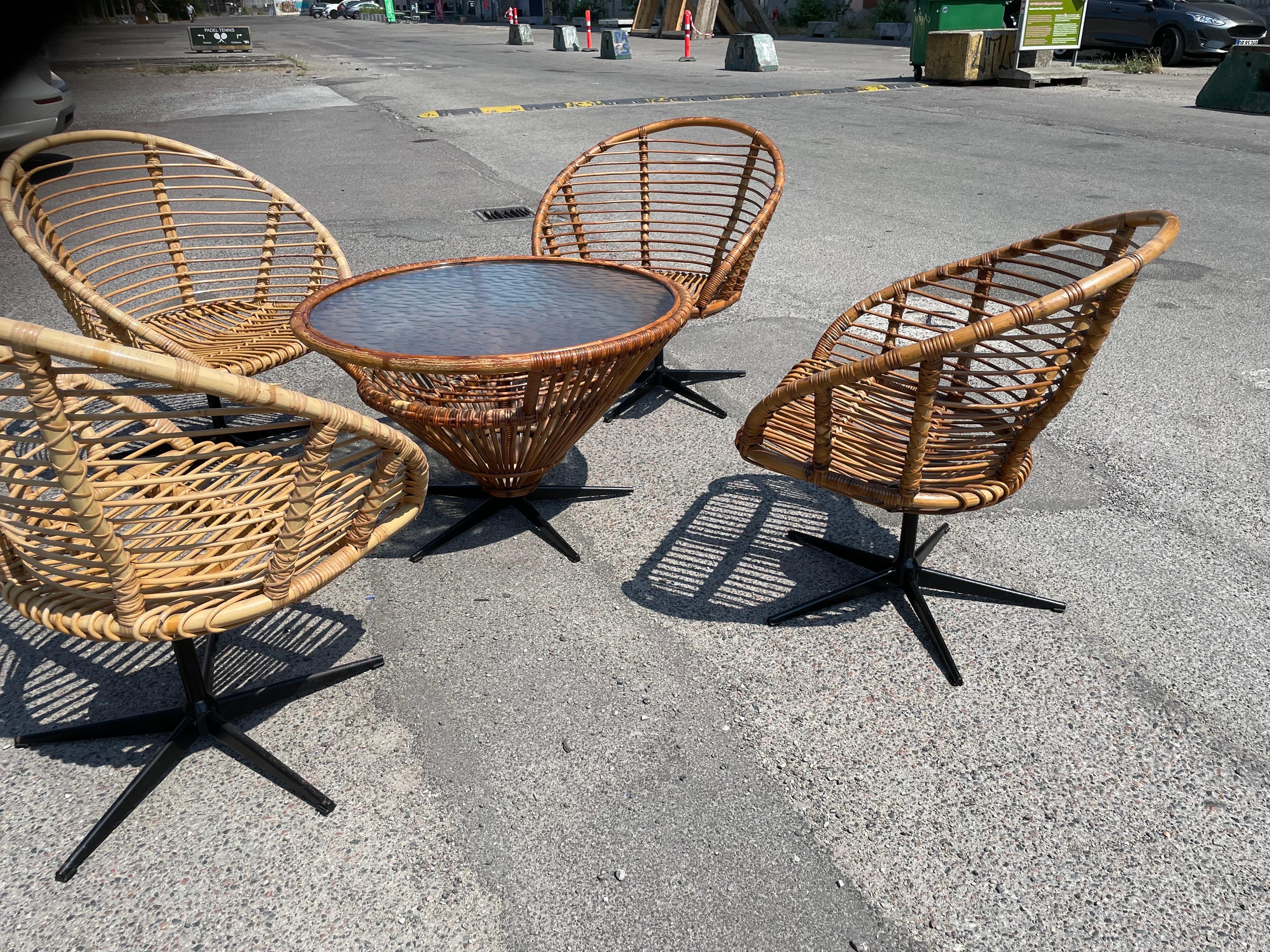 Mid-Century Modern Set of four rattan swivel chairs with a matching table from the 1960´s For Sale