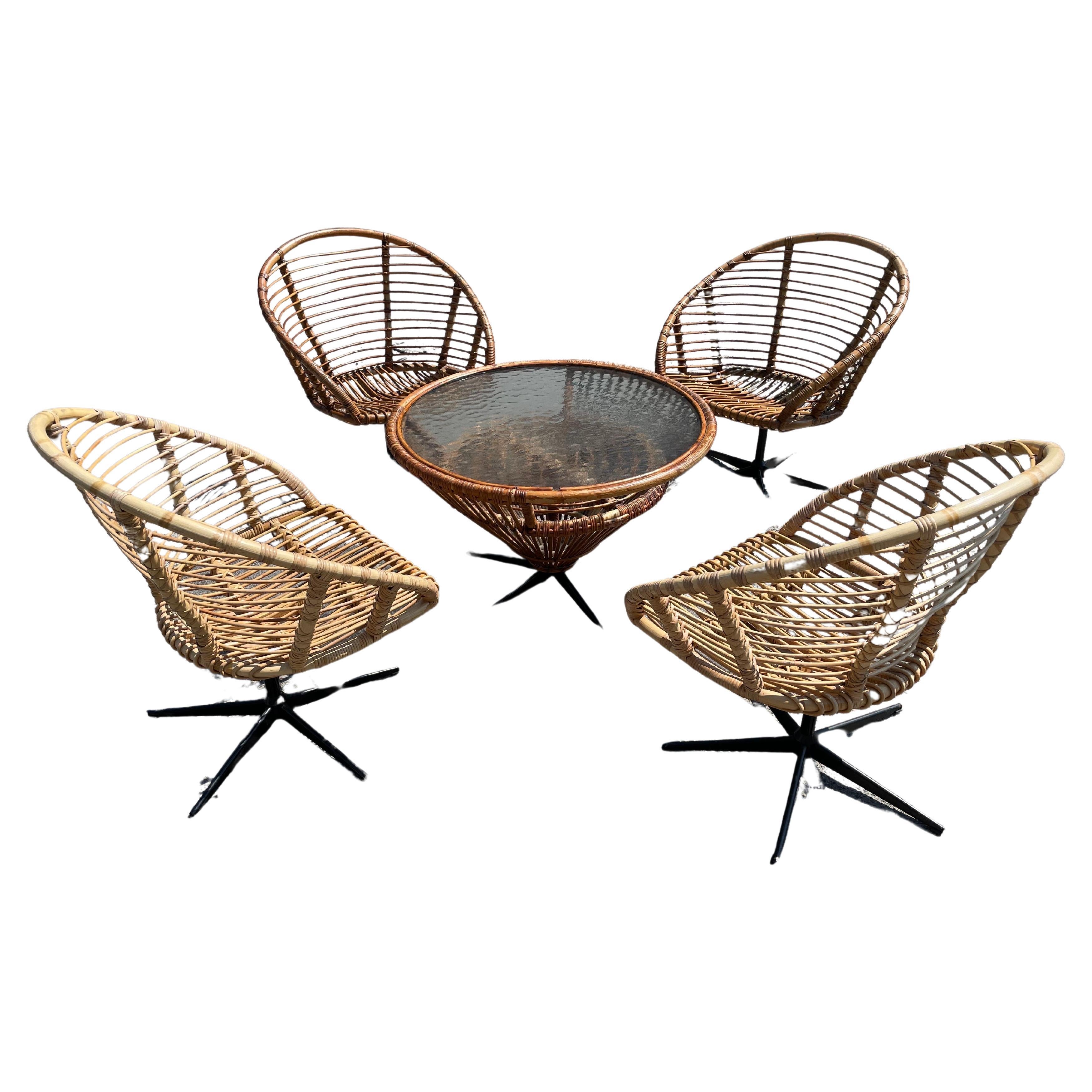Set of four rattan swivel chairs with a matching table from the 1960´s For Sale