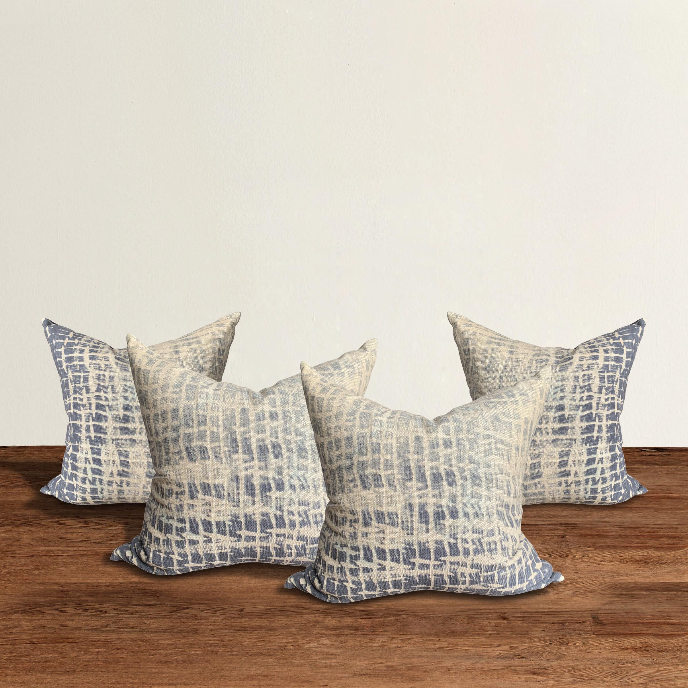 A chic set of four raw silk pillows with an indigo ombre silk screen printed pattern across the faces, and solid indigo silk backings, with mother of pearl buttons and down inserts.